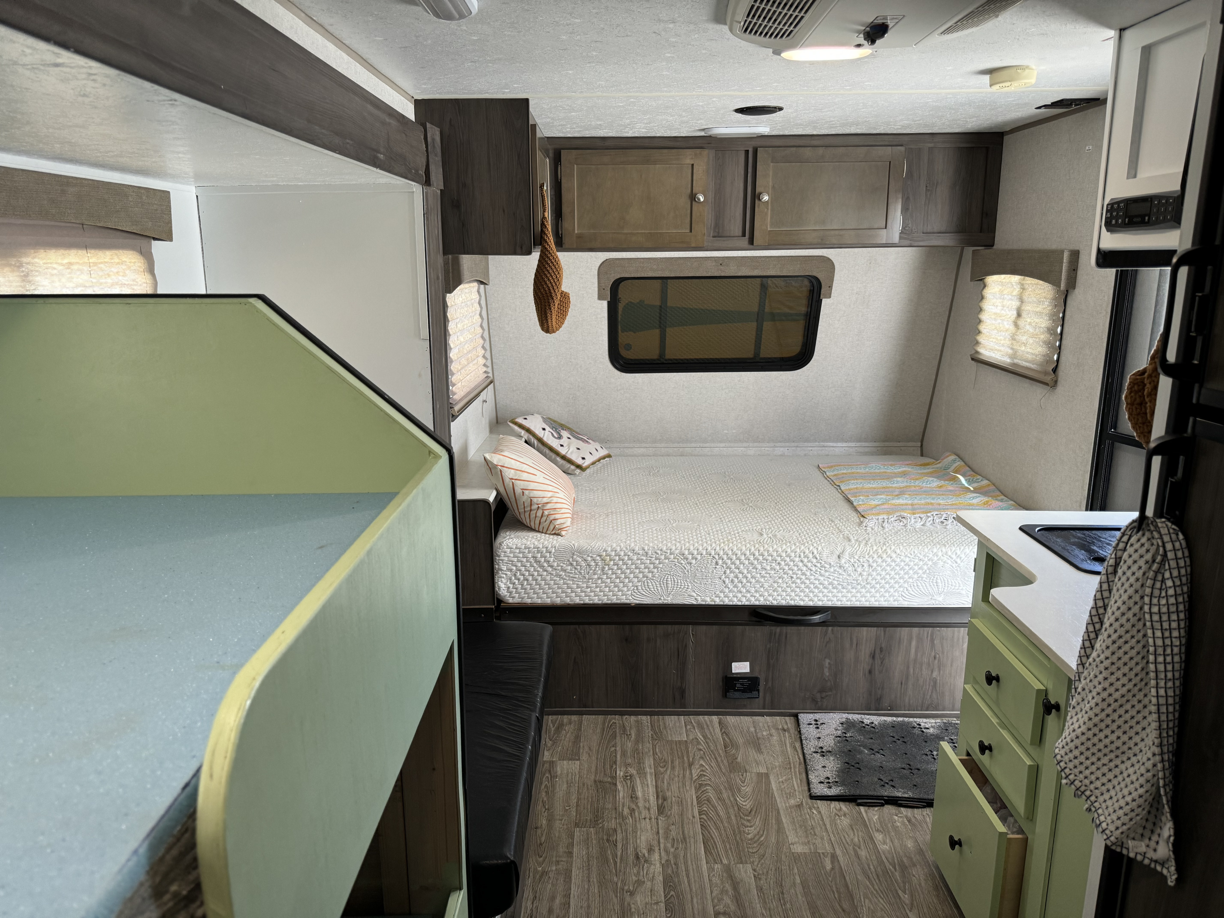 Bright RV rental camper interior with a cozy main bed, bunk beds, and a compact kitchen.. Forest River Viking 2019