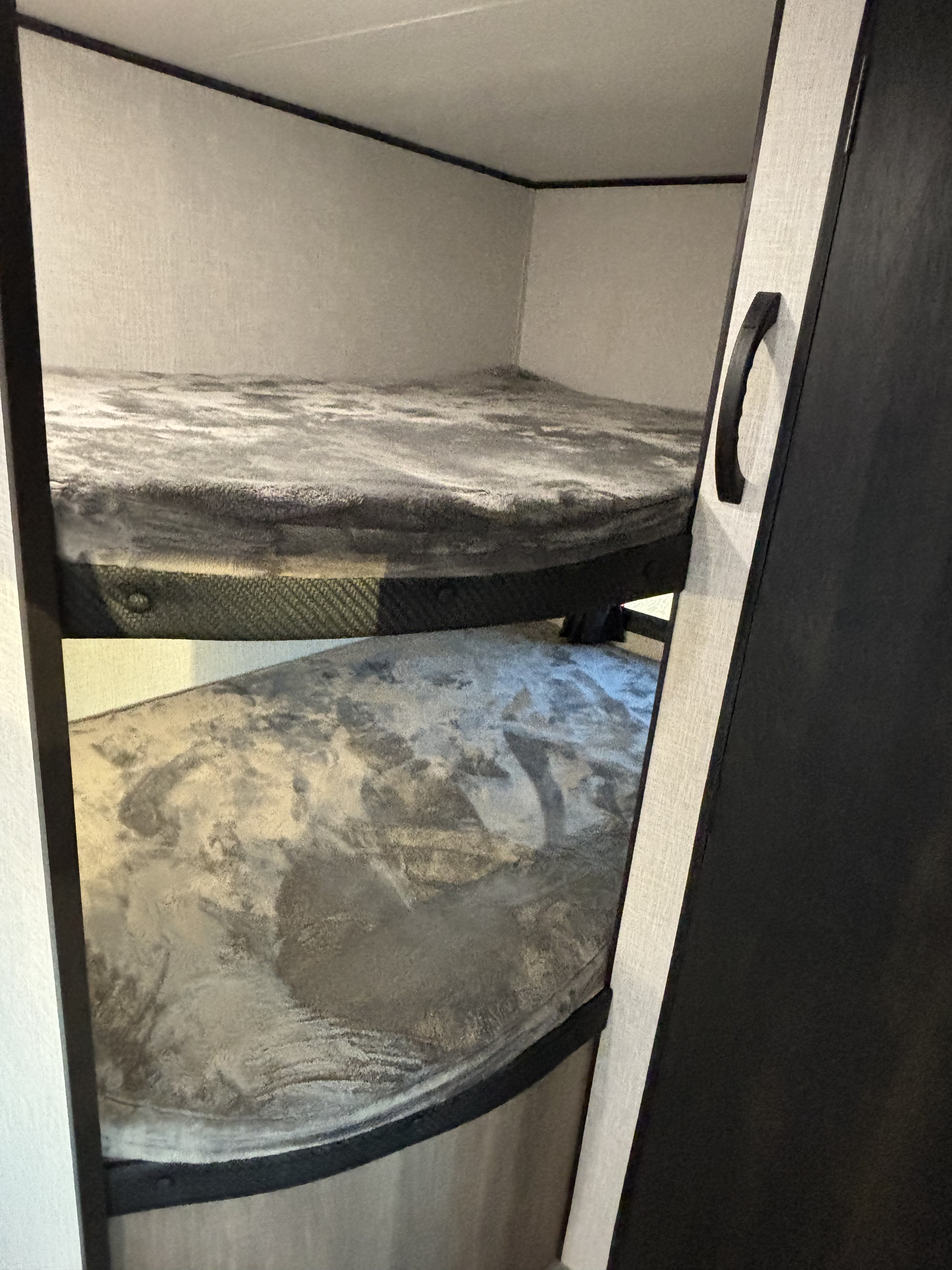 Inside an RV rental, two bunk beds with plush gray blankets offer cozy sleeping space.. Jayco Jay Flight SLX 2024