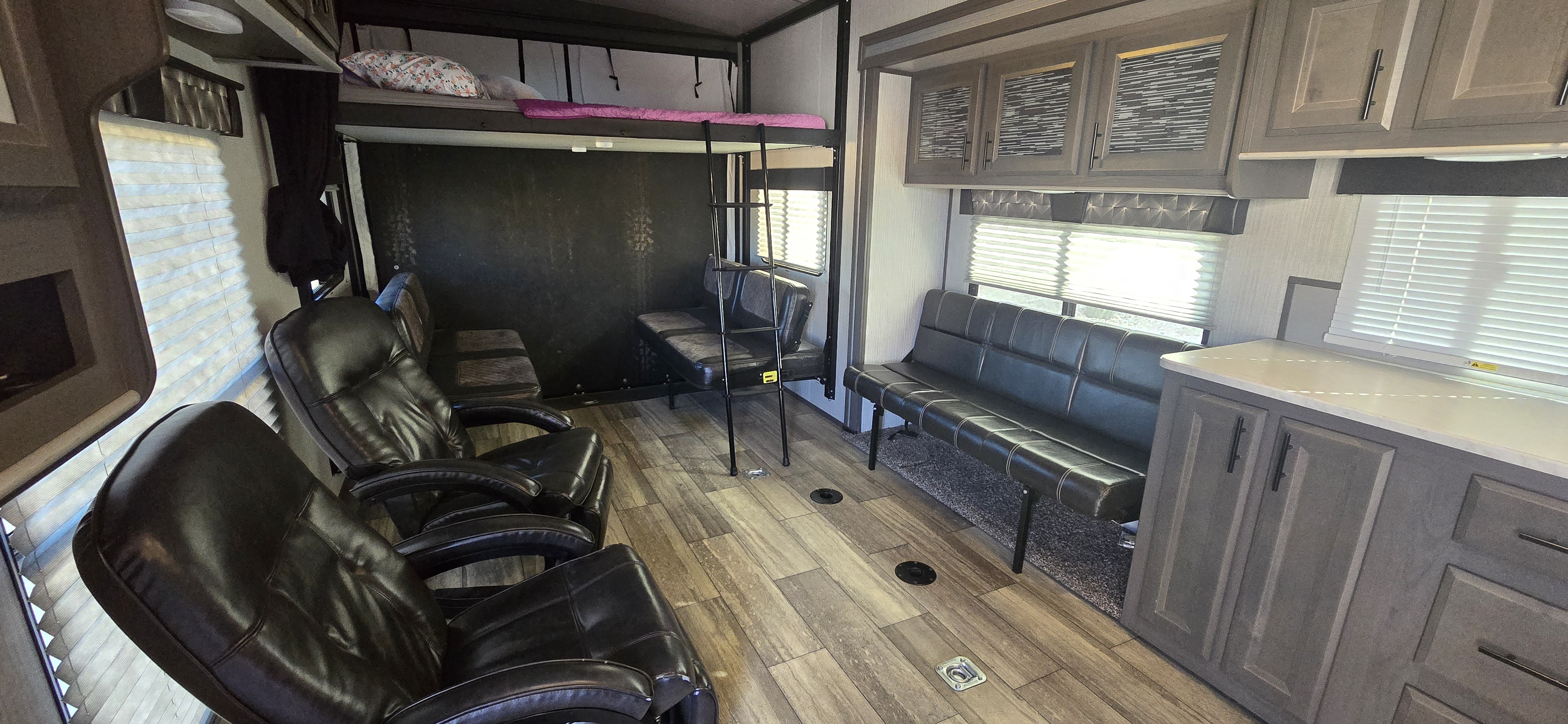 Spacious rv rental interior featuring a bunk bed, recliners, and benches for versatile living and hauling space.. Heartland Fuel 287 2020