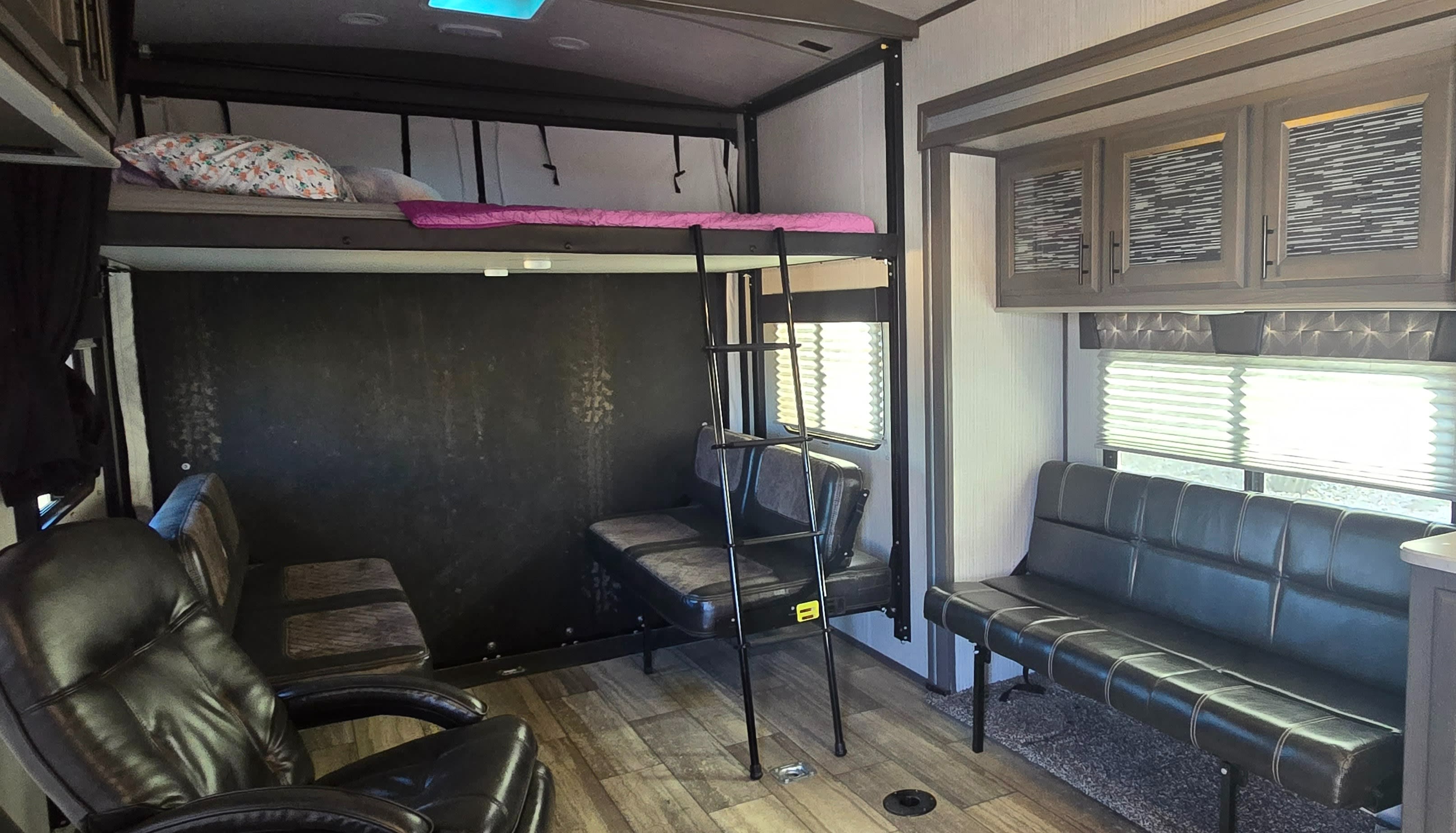 Inside a comfortable **rv rental**: bunk bed, sofa, chairs, and ample living space. Ideal for family adventures.. Heartland Fuel 287 2020