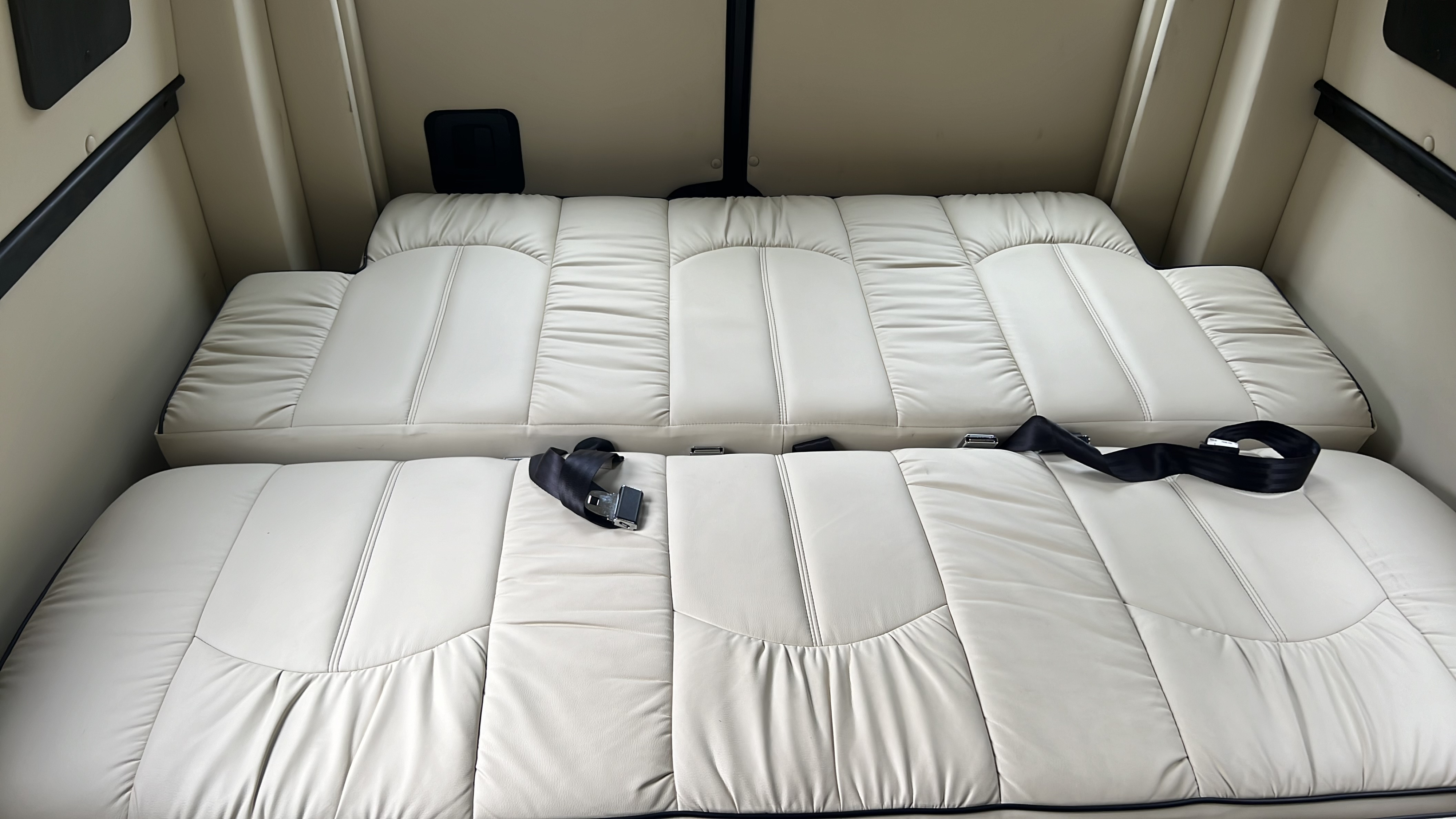 RV rental: View inside a cream-colored camper, showing convertible seating that unfolds into a comfortable bed.. Midwest Automotive Designs Midwest Automotive Designs Class B 2021