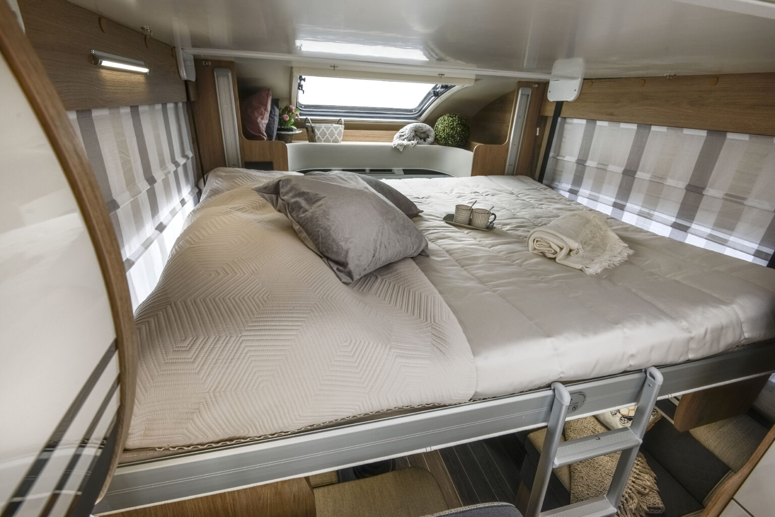 RV rental: A cozy elevated bed with ladder, pillows, and window, ready for a restful night on the road.. Roller Team 707 Auto Roller 2025