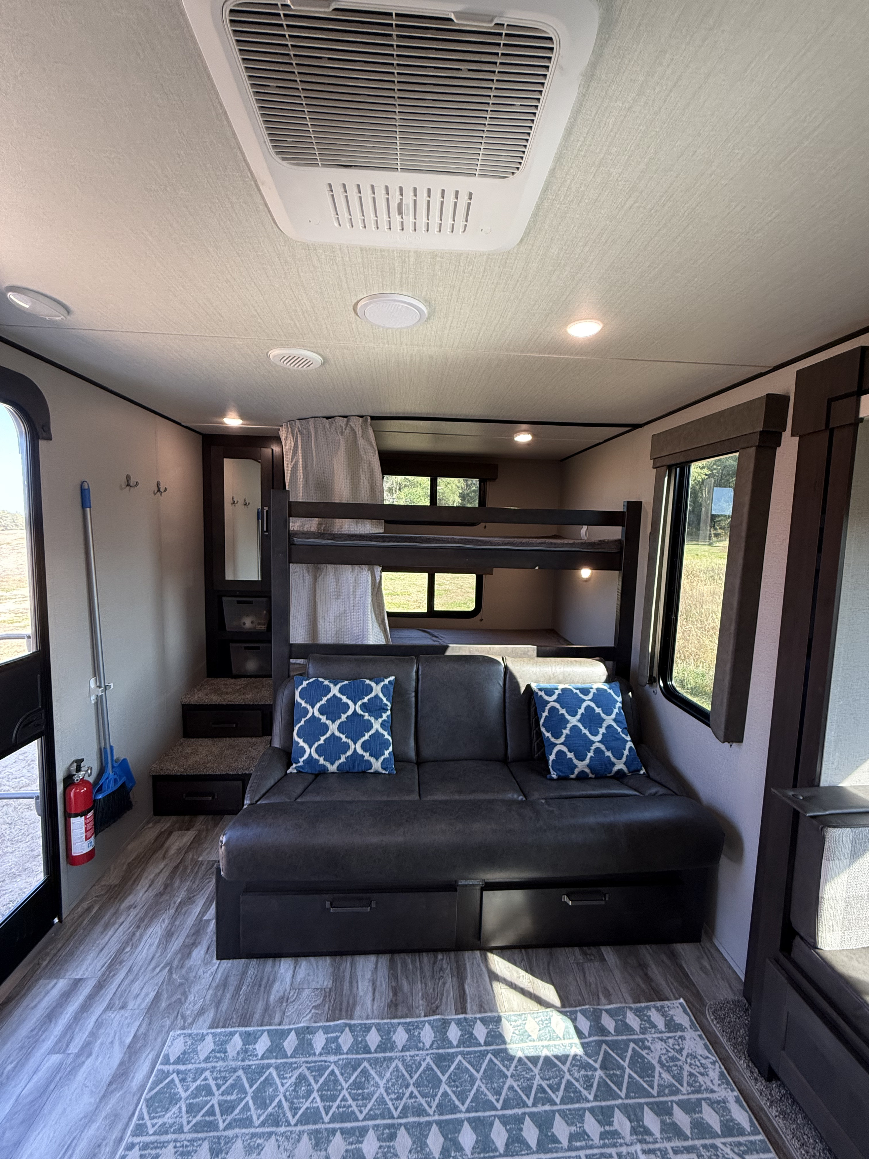Inside a modern RV rental: Features include comfortable bunk beds, a pull-out sofa with storage, and ample natural light.. Grand Design Transcend Xplor 2021