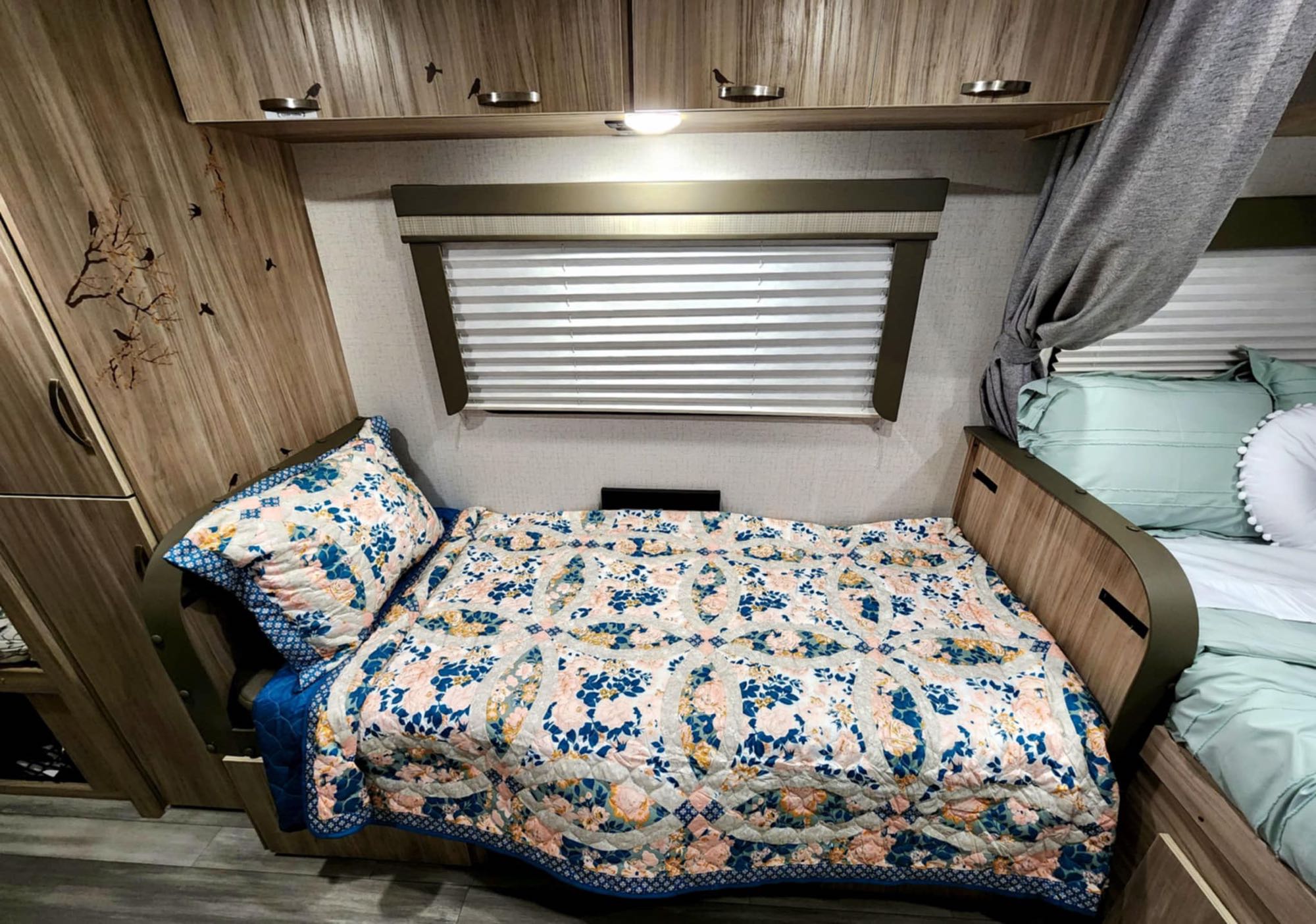 Cozy RV rental interior with floral quilted sleeping areas, privacy blinds, and decorative bird details.. Winnebago Micro Minnie 1800BH 2022