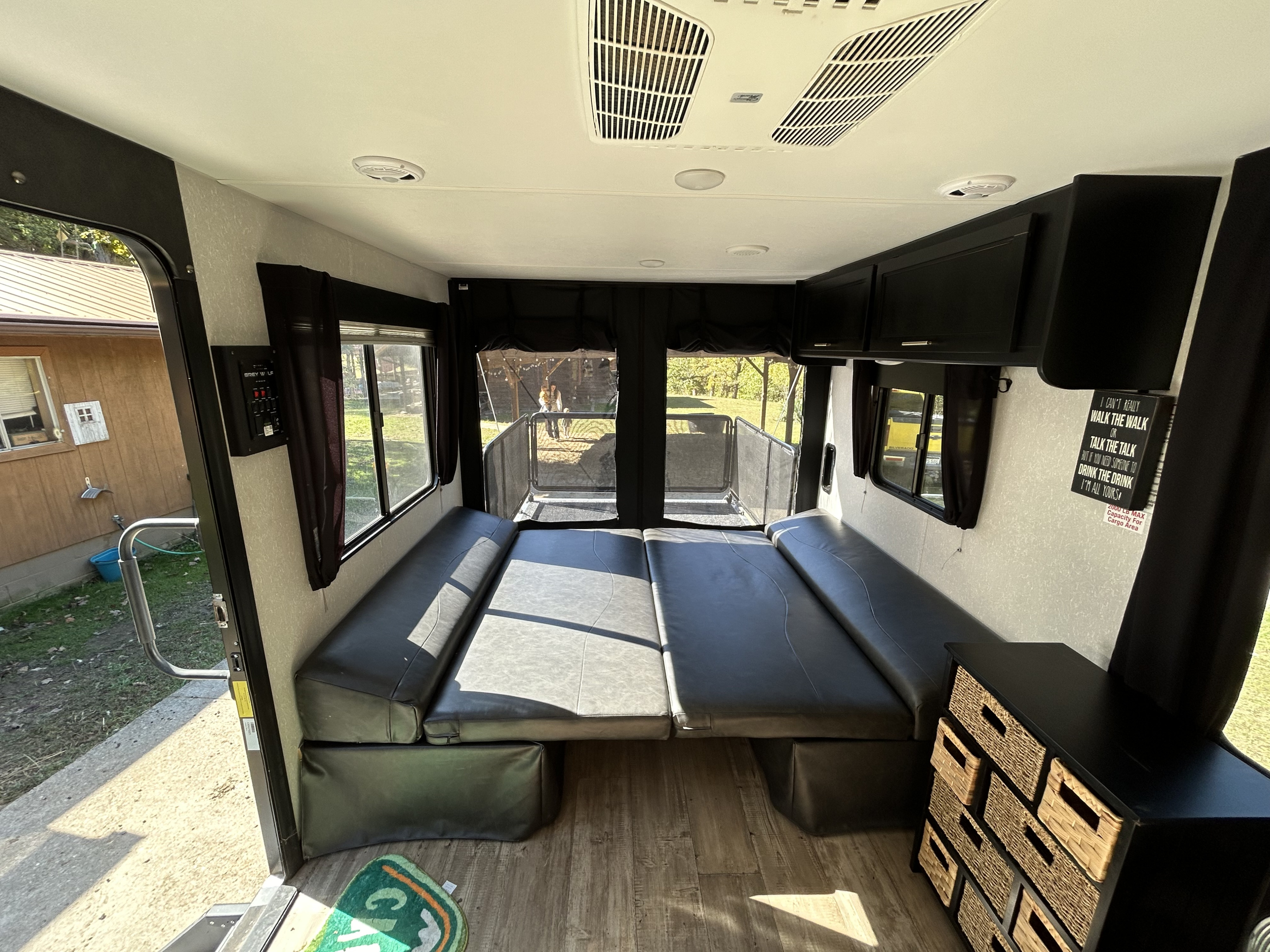 Spacious RV rental toy hauler interior featuring convertible seating/bed, AC, and a rear patio access ramp.. Forest River Cherokee Grey Wolf 2021