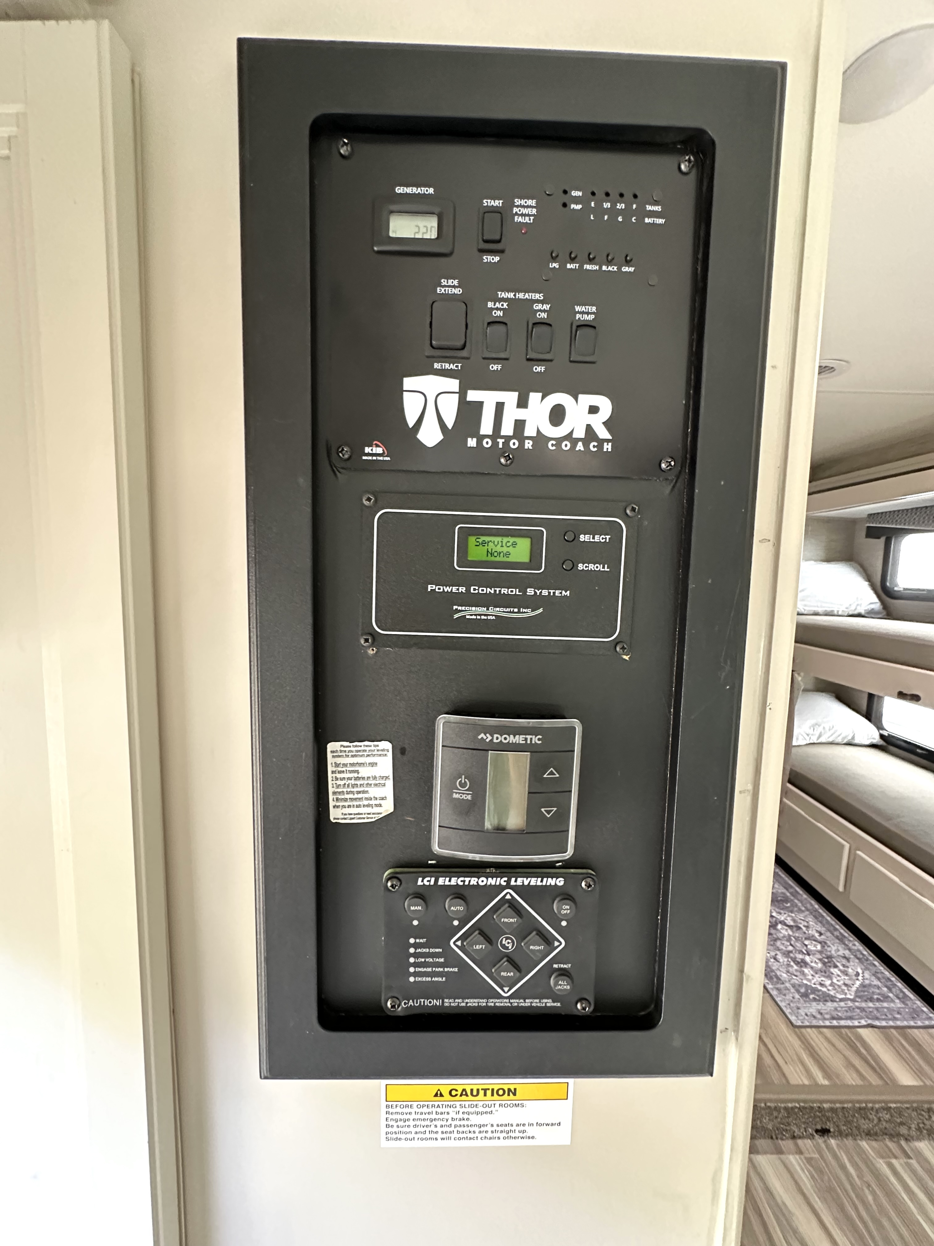 RV rental control panel displays generator, slide-out, leveling, and tank controls inside a motorhome.. Thor Four Winds 2022