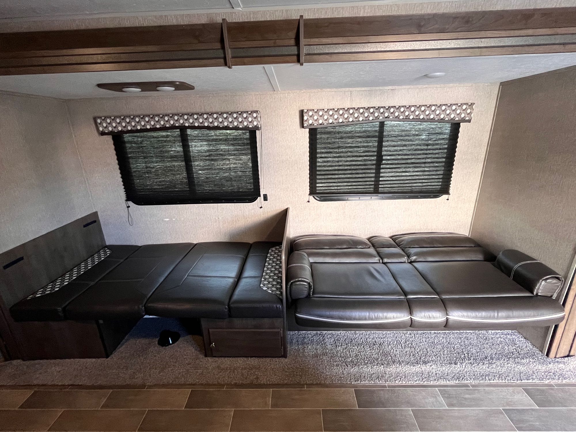 RV rental with dark leather seating, convertible to beds, and two windows with blinds, perfect for a cozy trip.. Dutchmen Coleman Lantern 2019