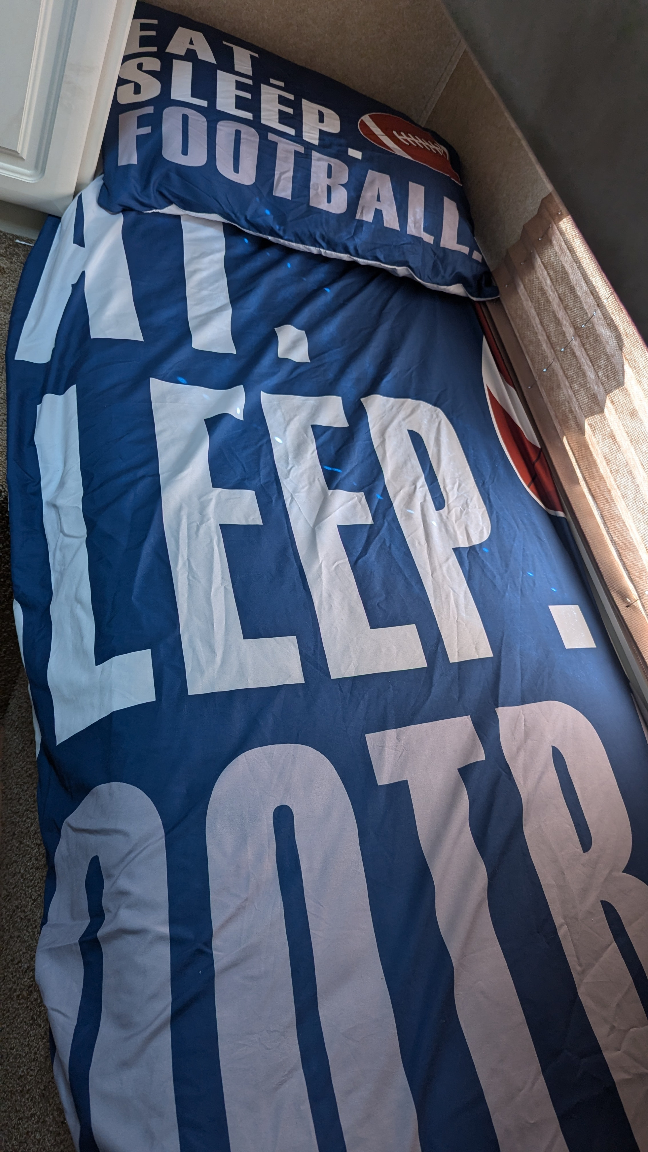 RV rental bed featuring "Eat Sleep Football" bedding, perfect for a sports fan's comfortable travels.. Keystone RV Outback Sydney 2006