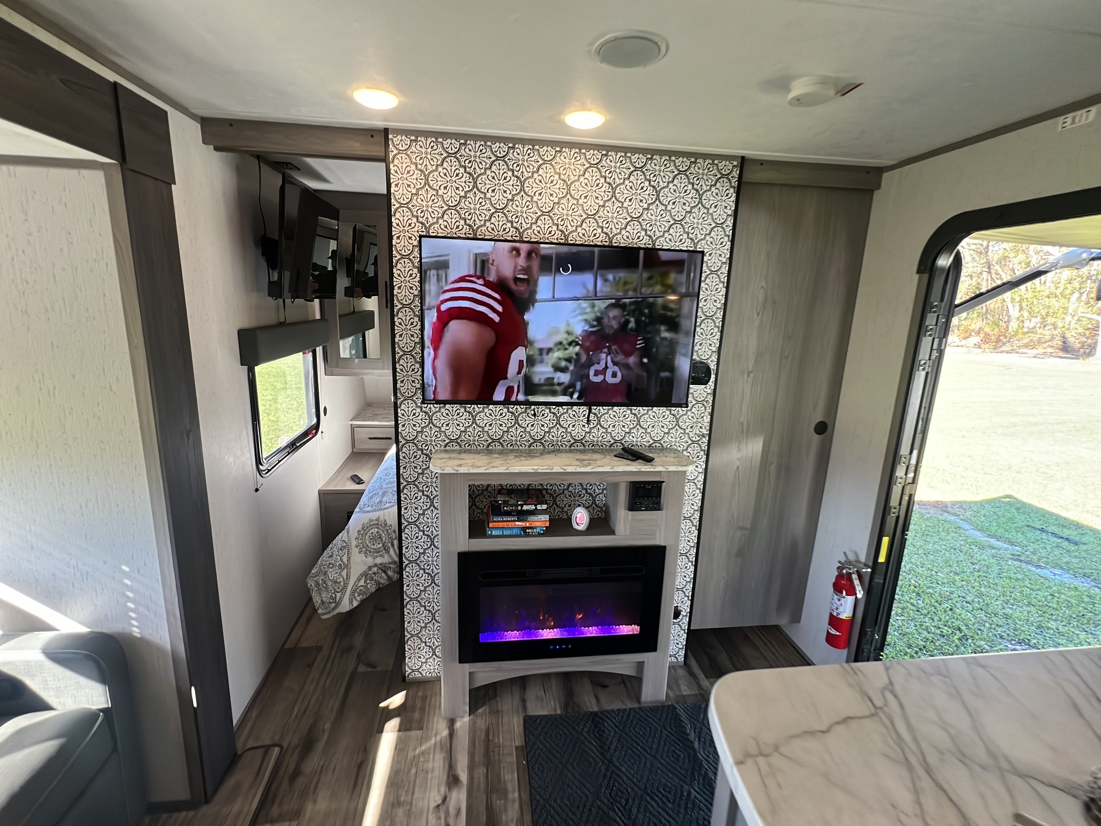 RV rental: Cozy interior showing TV, fireplace, bedroom area, and open door to the outdoors. Perfect for a relaxing getaway.. Dutchmen Coleman Lantern 2023