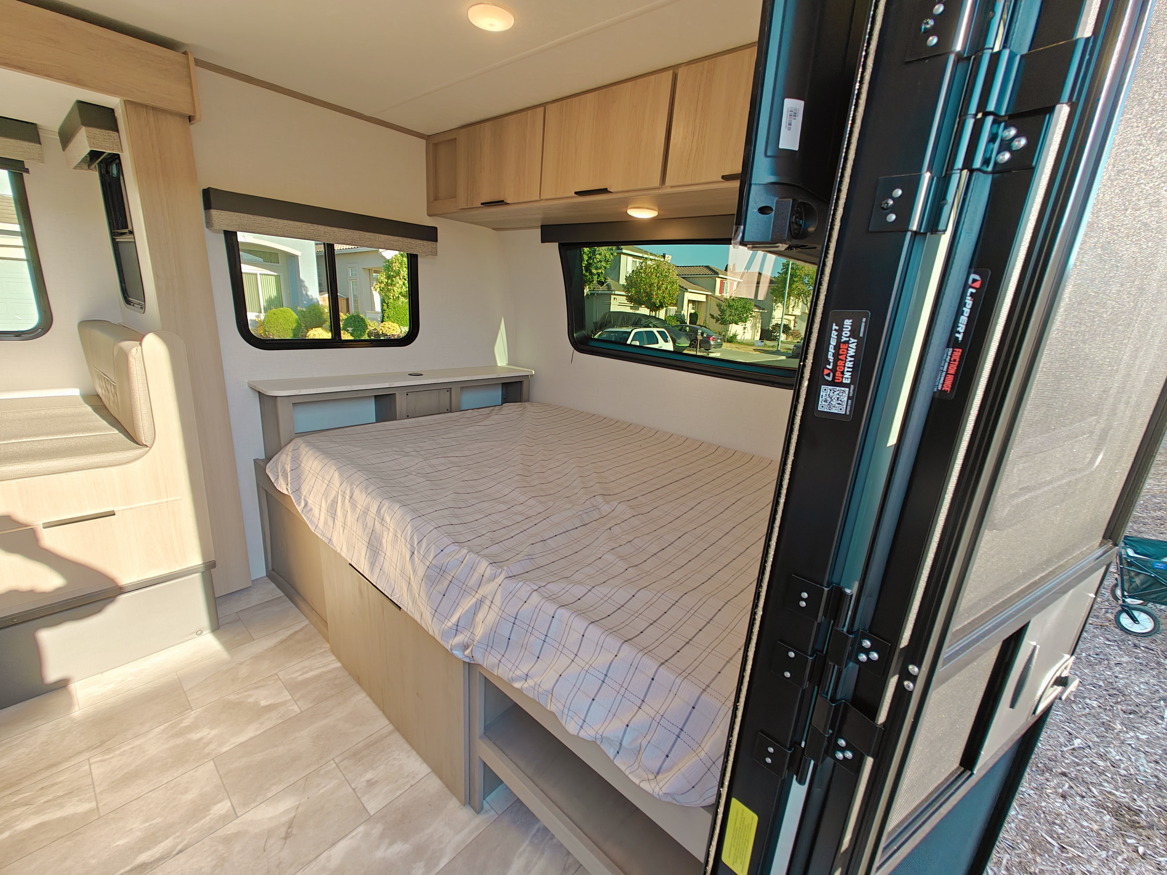 Cozy RV rental interior: features a comfortable bed, ample storage in overhead cabinets, and a side dinette. Bright windows offer views.. Dutchmen Kodiak Cub 170BH 2025