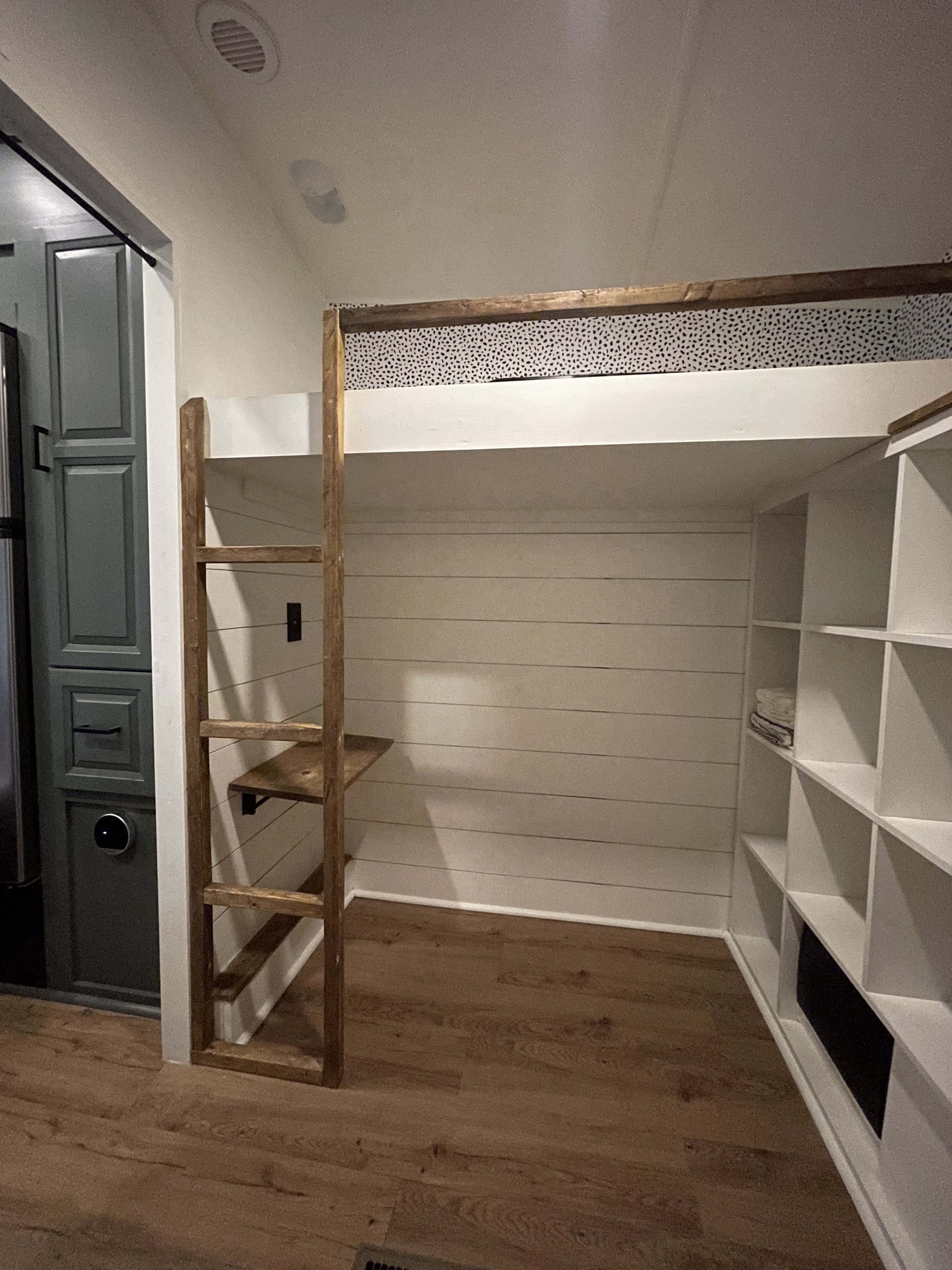 Compact RV rental interior featuring a stylish bunk bed, desk, and ample storage shelves.. Forest River Wildcat Extralite 2013