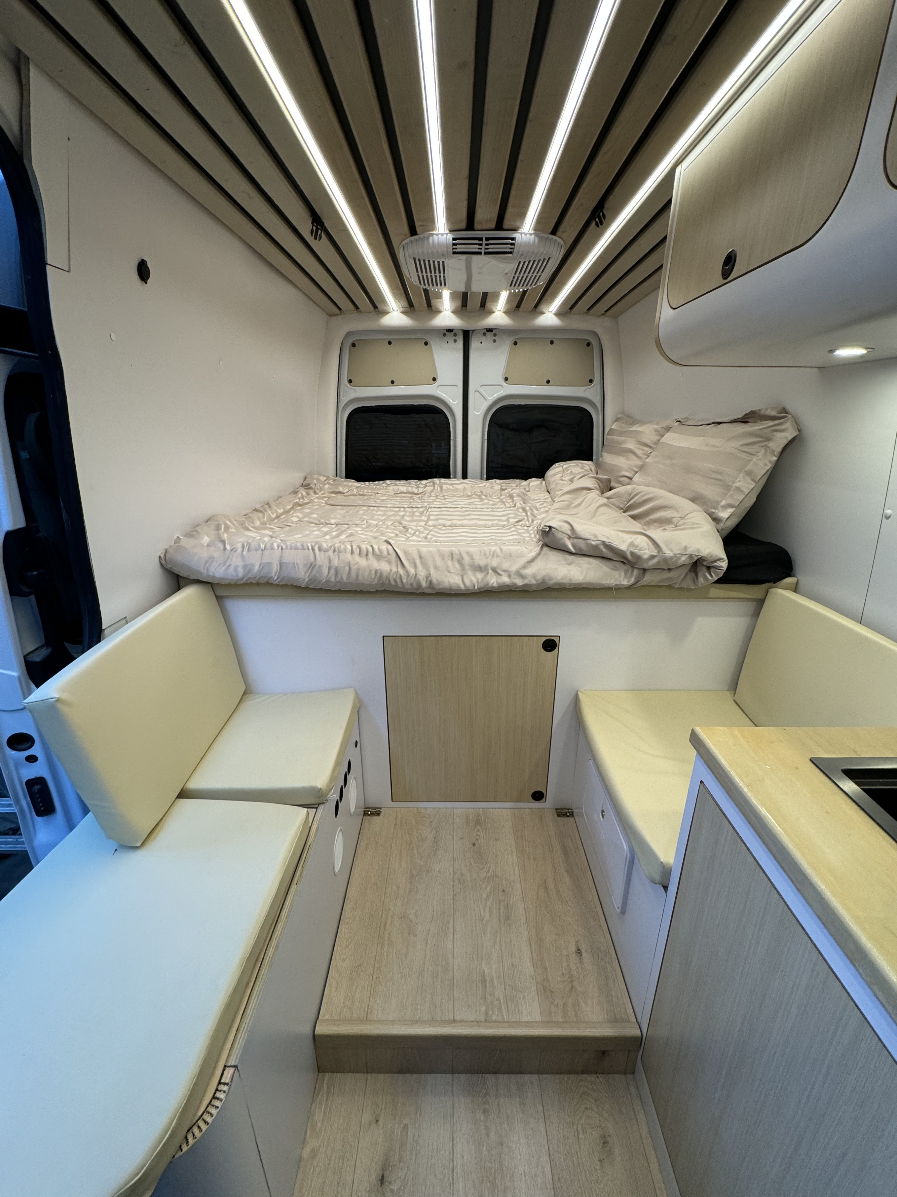 Step inside this clean, modern RV rental. Enjoy the cozy bed, bench seating, and compact kitchen.. Mercedes-Benz Sprinter 2022