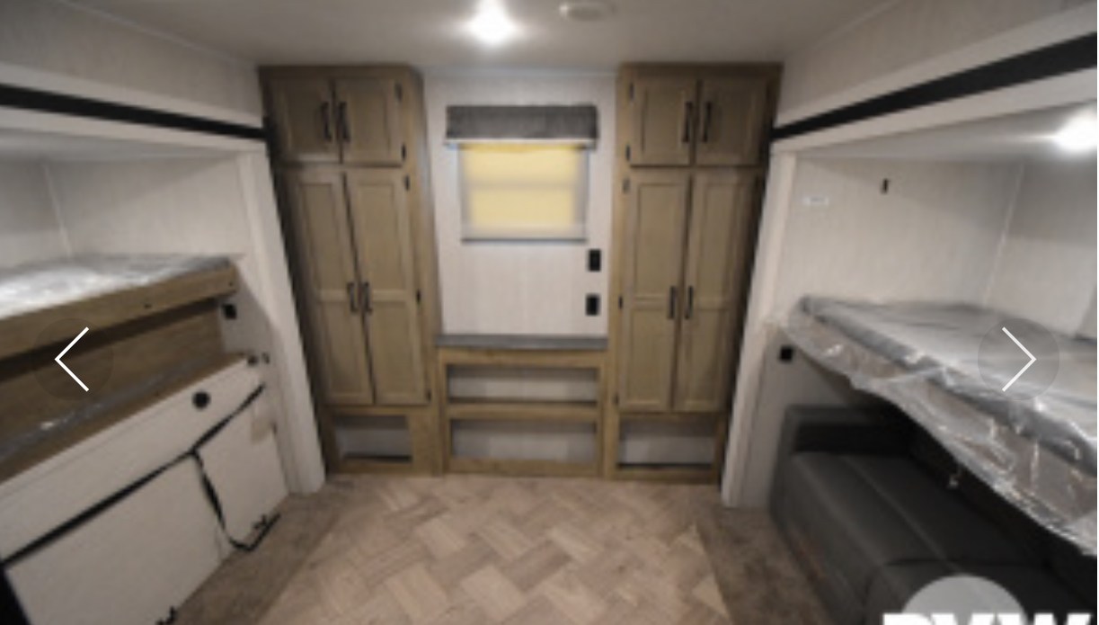 Inside this RV rental: two sets of bunk beds, central window flanked by tall storage cabinets, and a lower bench. Efficient design.. Palomino Puma Park Trailer 2021