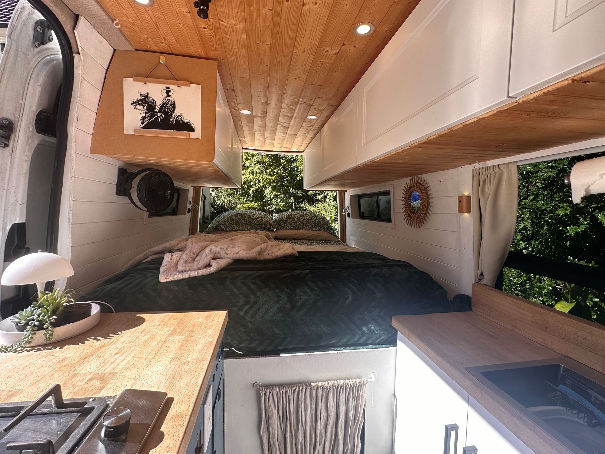 Cozy camper van interior featuring a comfortable bed, compact kitchen with stove & sink. Ideal for an RV rental getaway.. Mercedes Sprinter 2007