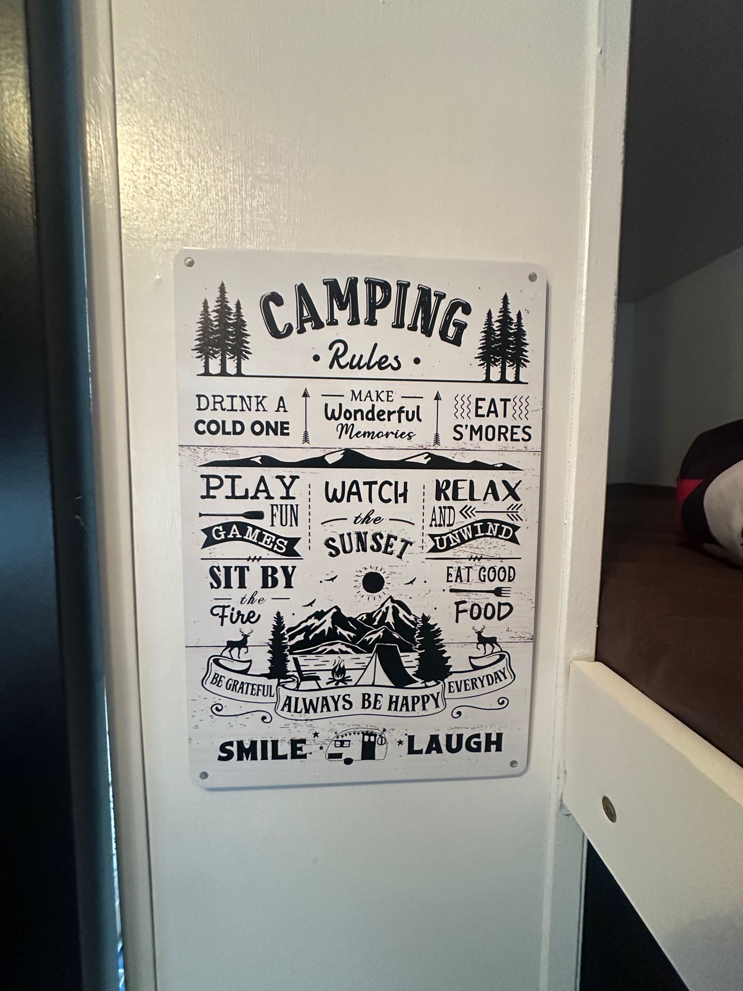 A white "CAMPING Rules" sign with black text & graphics, listing fun outdoor activities like s'mores, perfect for an rv rental.. Keystone Hideout 2016