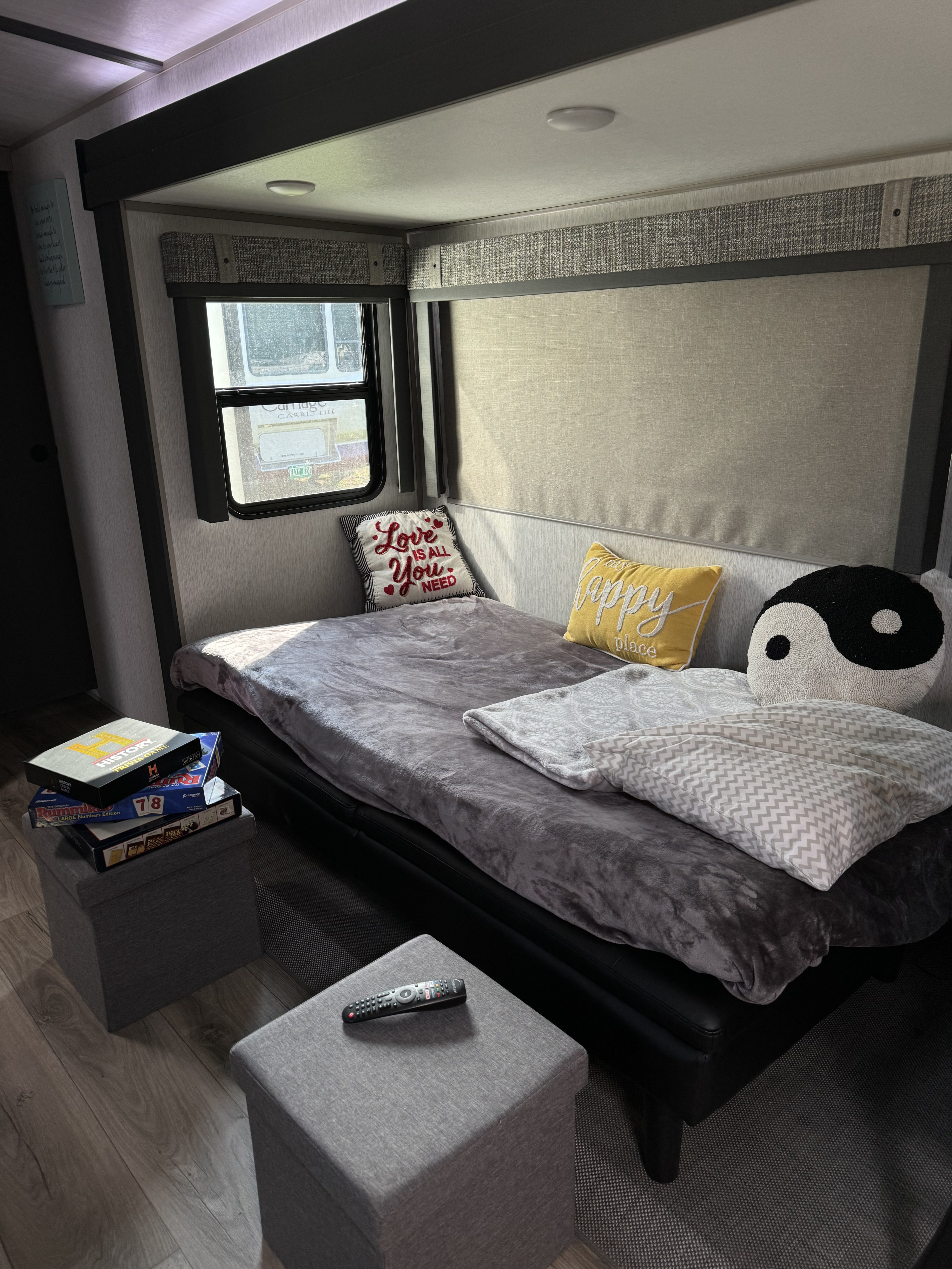 Cozy RV rental interior: Daybed with pillows, board games & ottomans for a relaxing stay. Perfect for travel!. Forest River Salem Hemisphere 2024