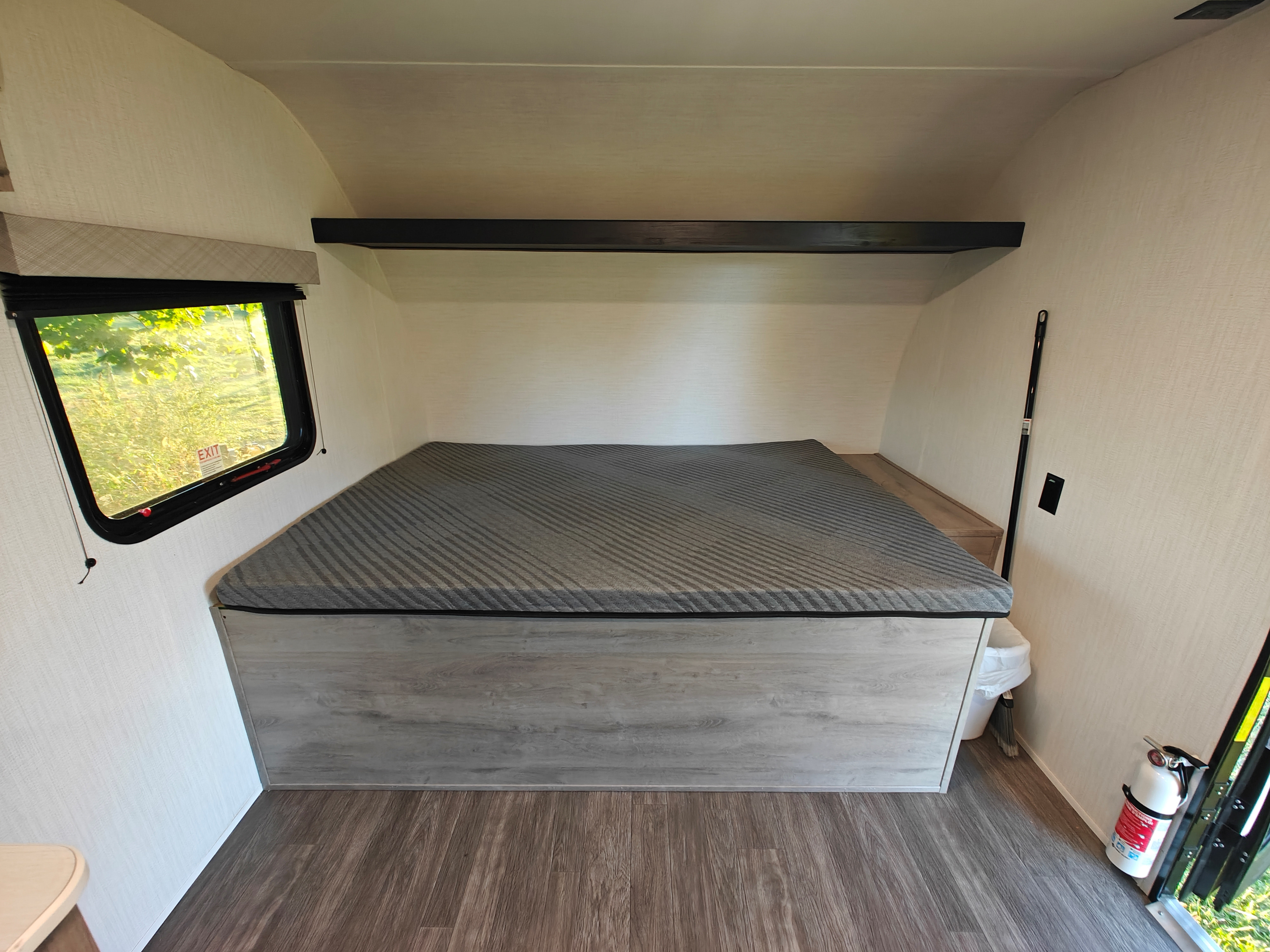 Inside an RV rental: Compact bedroom with a gray bed, overhead shelf, window, and essential safety gear.. CRUISER AVENIR CRUISER AVENIR 17RB 2025