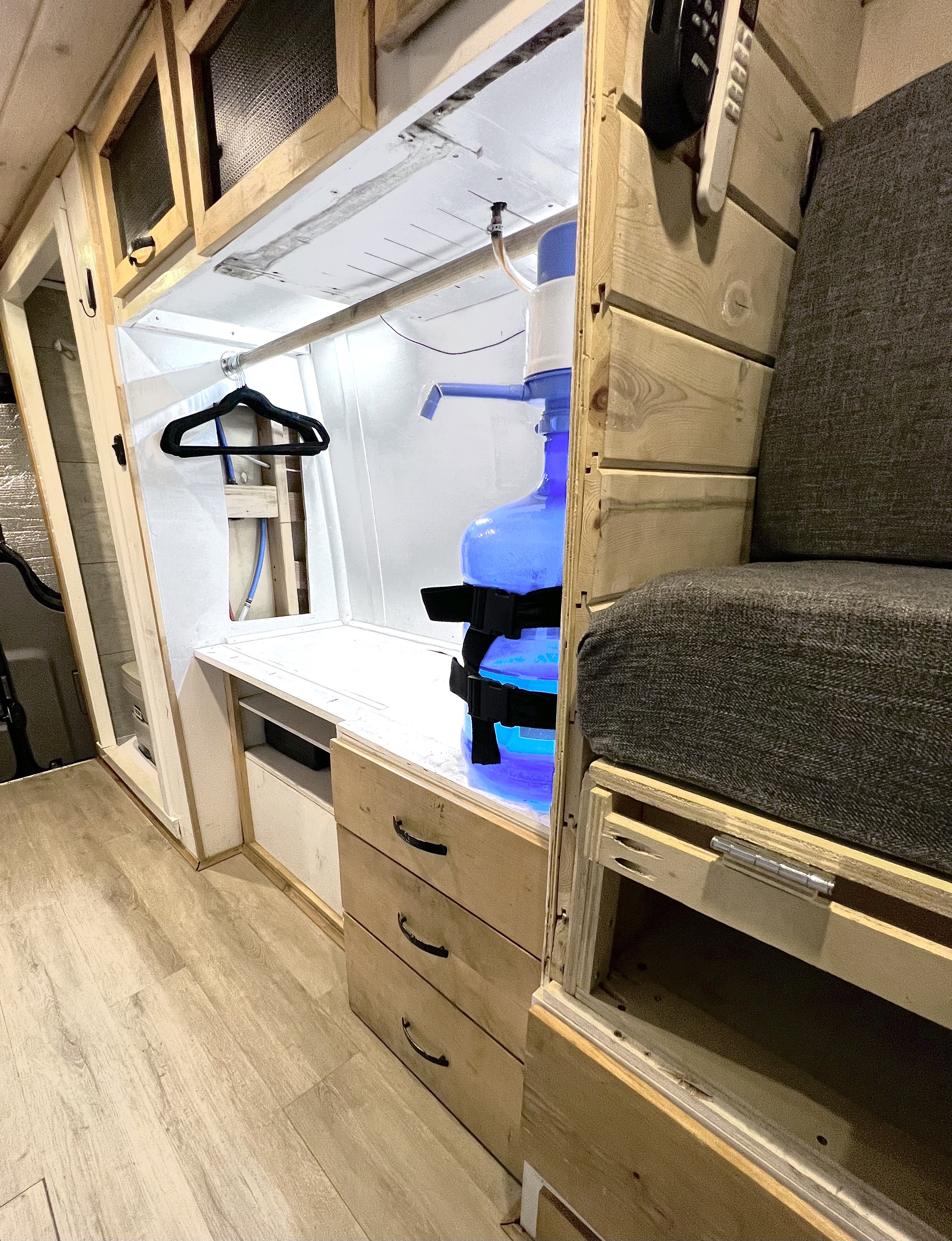 RV rental interior: Compact living space with water dispenser, storage, and seating for comfortable travel.. Mercedes-Benz Sprinter 2015