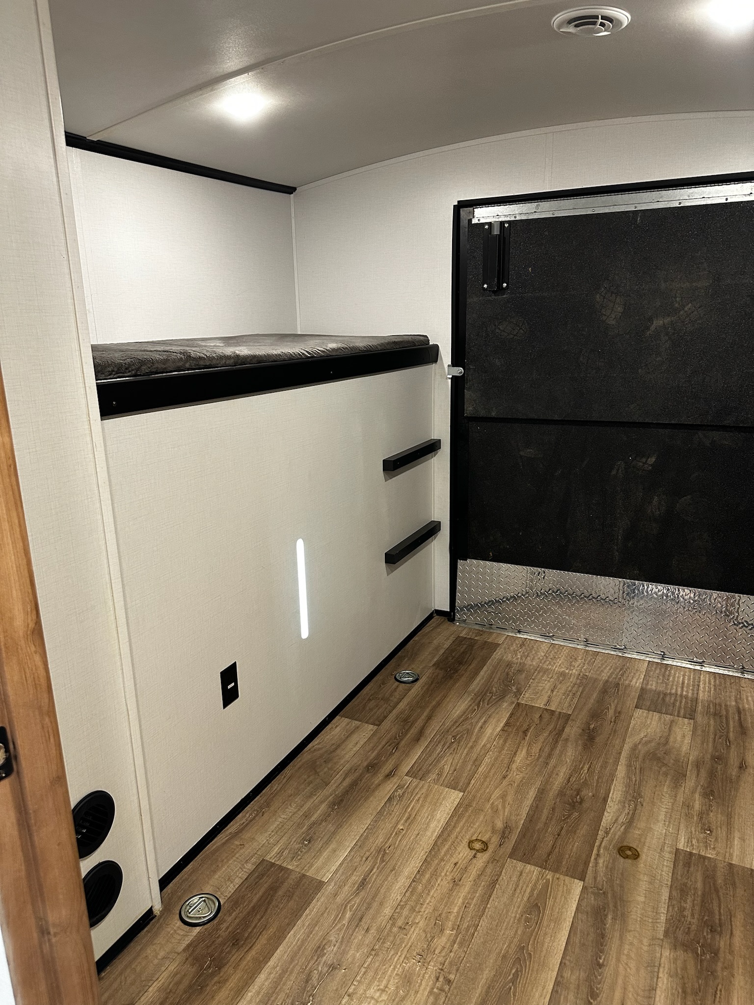 RV rental interior features bunk beds, wood flooring, and a rear ramp door with diamond plate trim, ideal for toy haulers.. Keystone RV Outback Toy Hauler 2023
