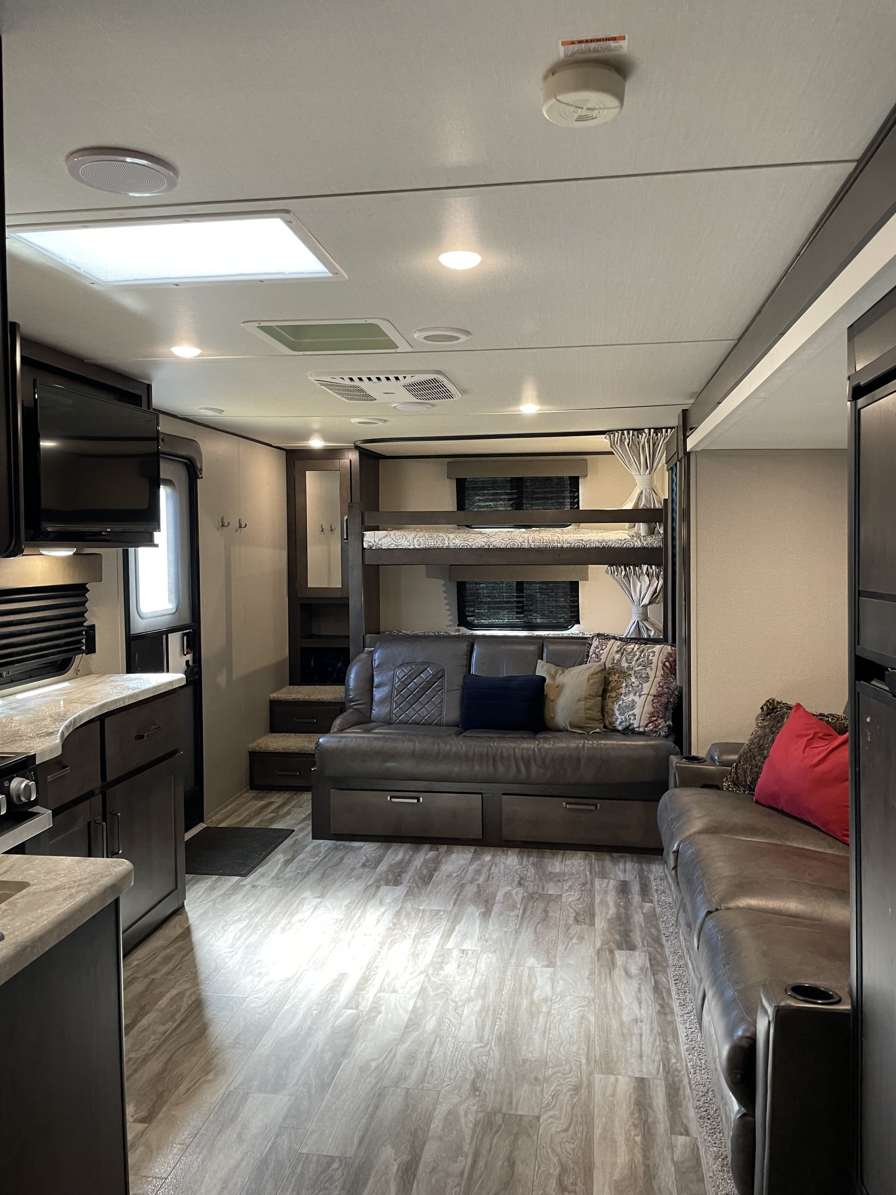 Spacious RV rental interior featuring a full kitchen, comfy living area, and bunk beds. Ready for your trip!. Grand Design Transcend 2021