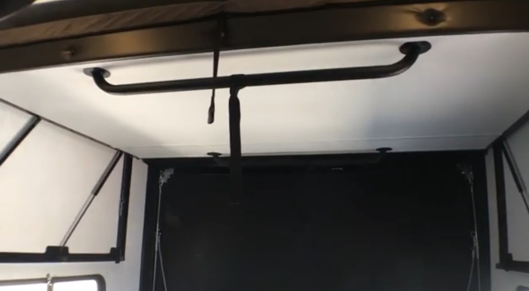 Inside an RV rental: Ceiling bar with hanging strap, liftable side panels, often found in toy hauler garages.. Forest River Vengeance Rogue Amored Toy Hauler 2021