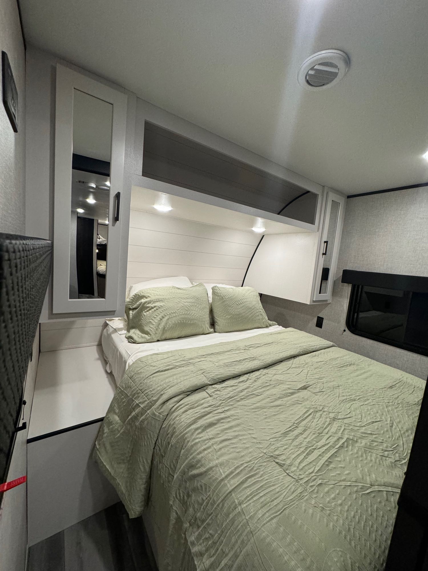 Modern RV bedroom: light green bedding, white shiplap, and overhead storage.. Jayco Jay Flight 2024