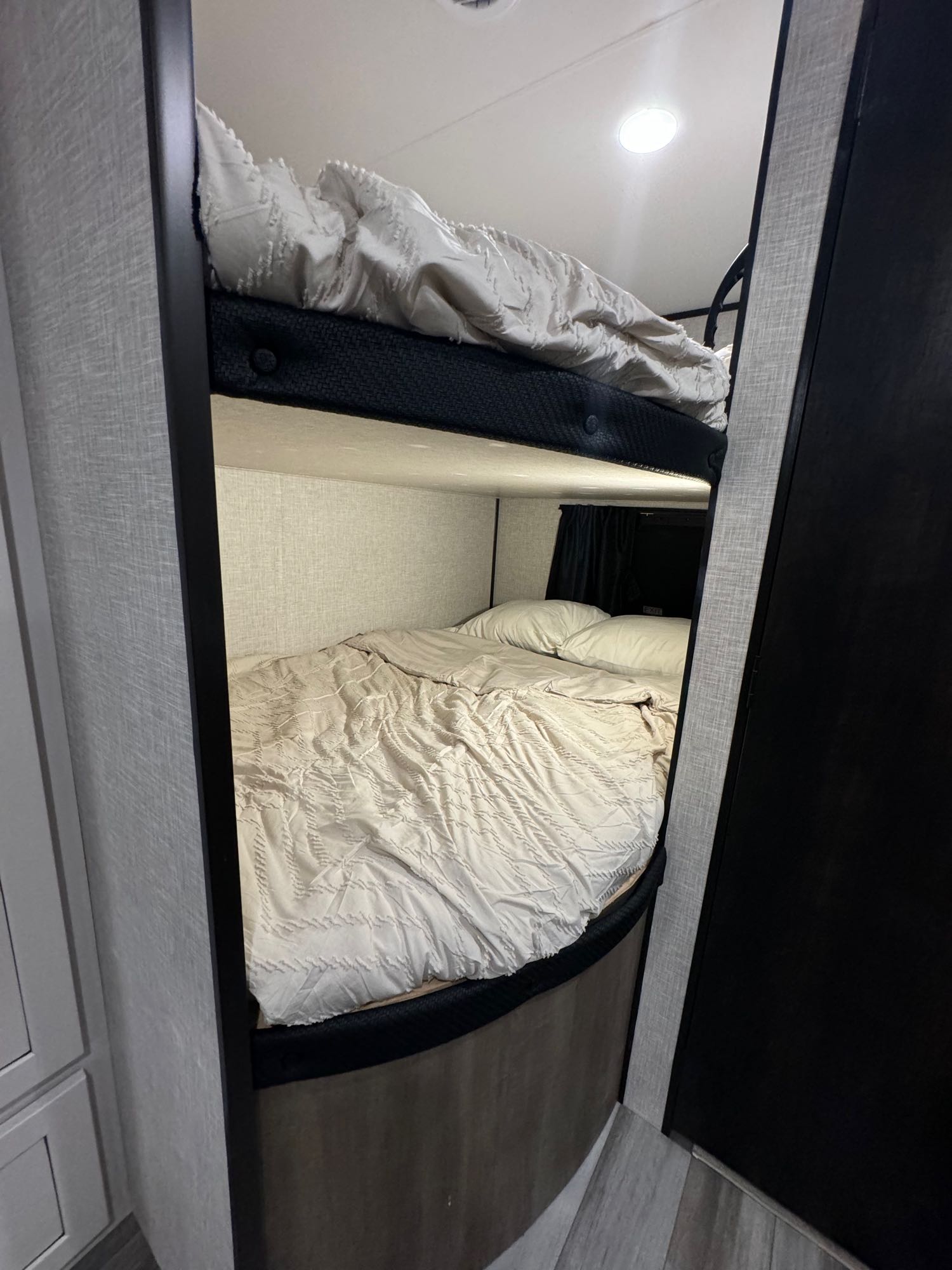 Cozy bunk beds with light bedding inside an RV rental, offering compact and comfortable sleeping space.. Jayco Jay Flight 2024