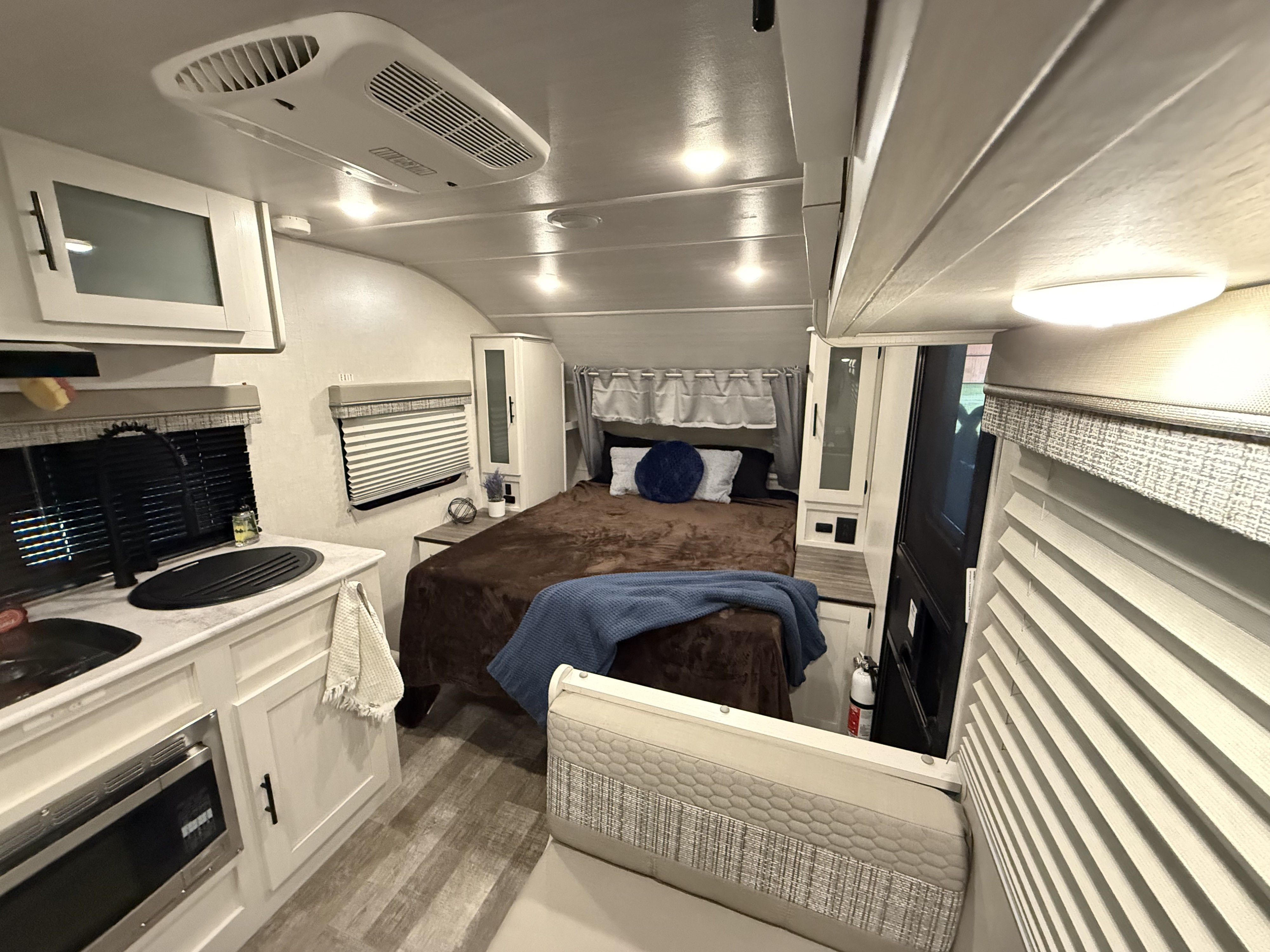 Explore this clean and functional RV rental interior, showcasing a compact kitchen, comfortable bed, and seating.. Forest River R-Pod 192 2022