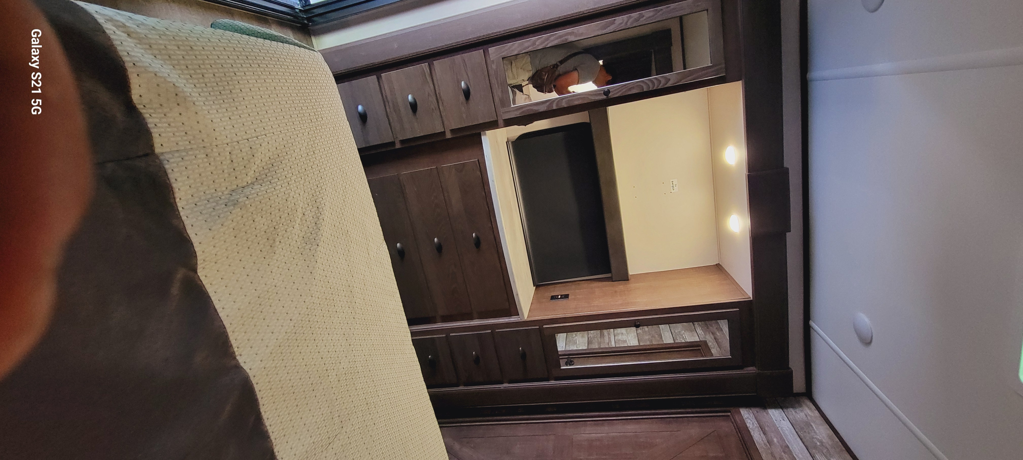 RV bedroom interior: textured bed cover, dark wood built-in unit with TV, storage, and lights. Perfect for an RV rental.. Forest River XLR Hyperlite HD 2020