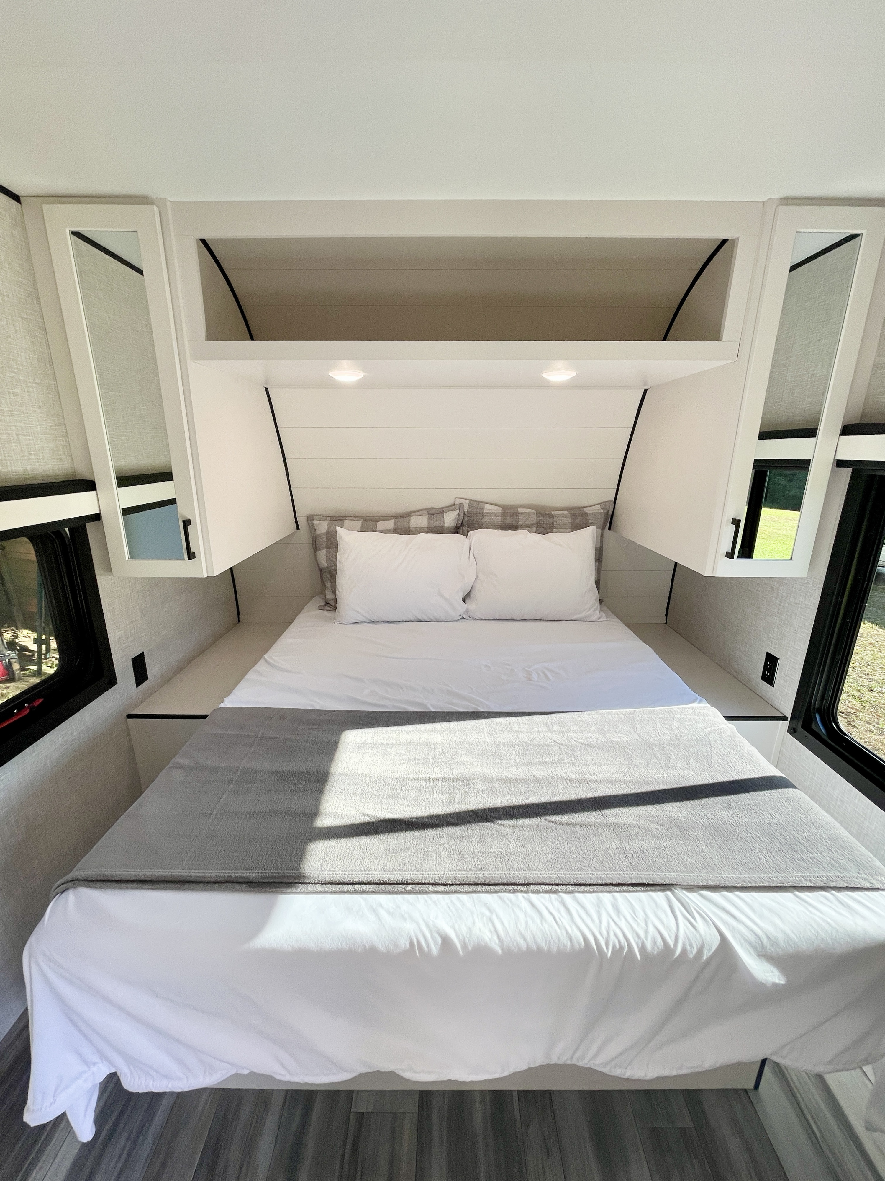Cozy and clean RV rental bedroom with modern white cabinetry, comfortable bed, and windows for natural light. Ideal for travel.. Jayco Jay Flight 2025