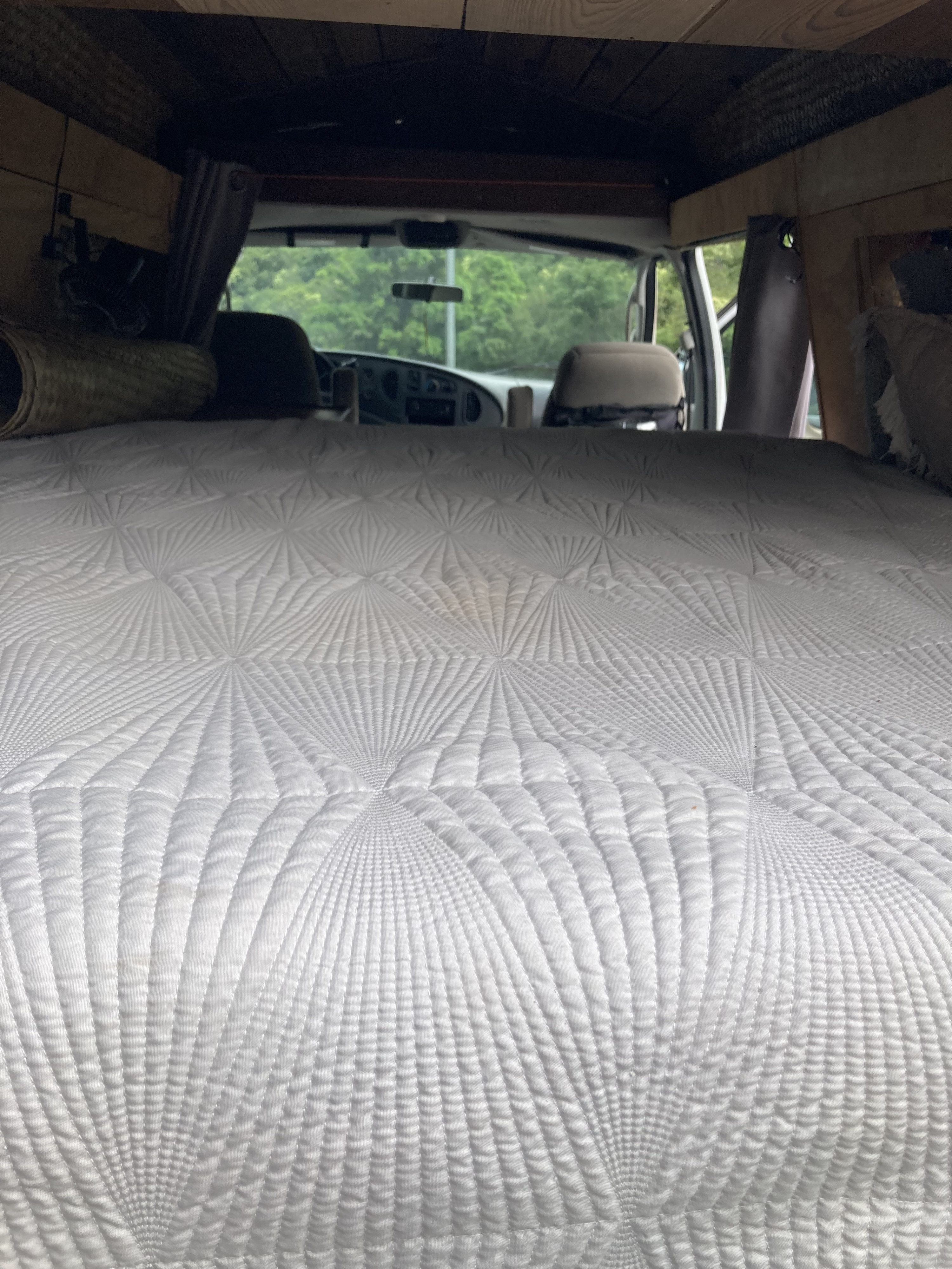 RV rental camper van interior featuring a comfortable white quilted bed.. FORD E-150 2004