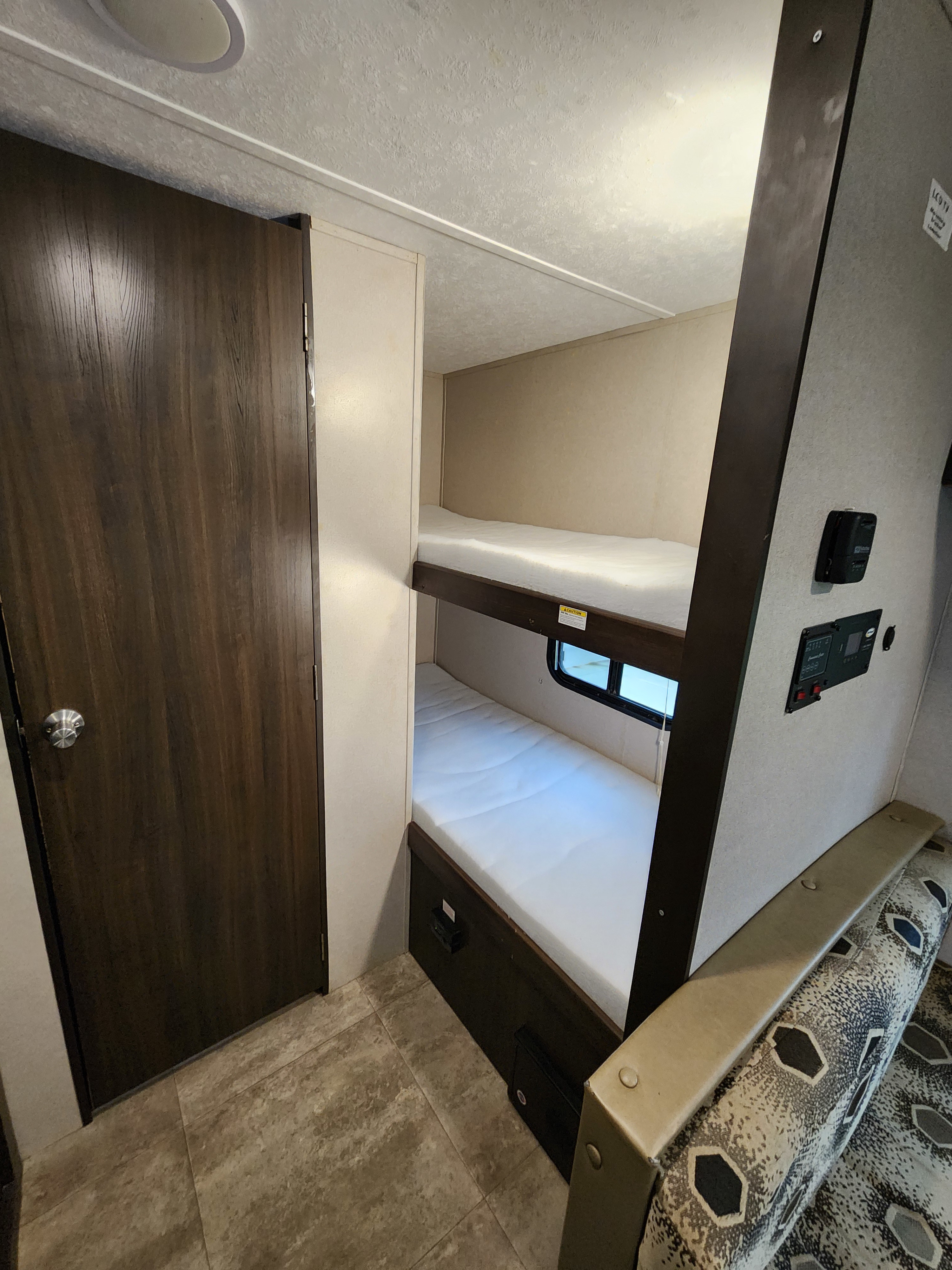 Inside this RV rental, find comfy bunk beds, a main door, and easy-access controls for a practical mobile home.. Keystone RV Springdale 2018