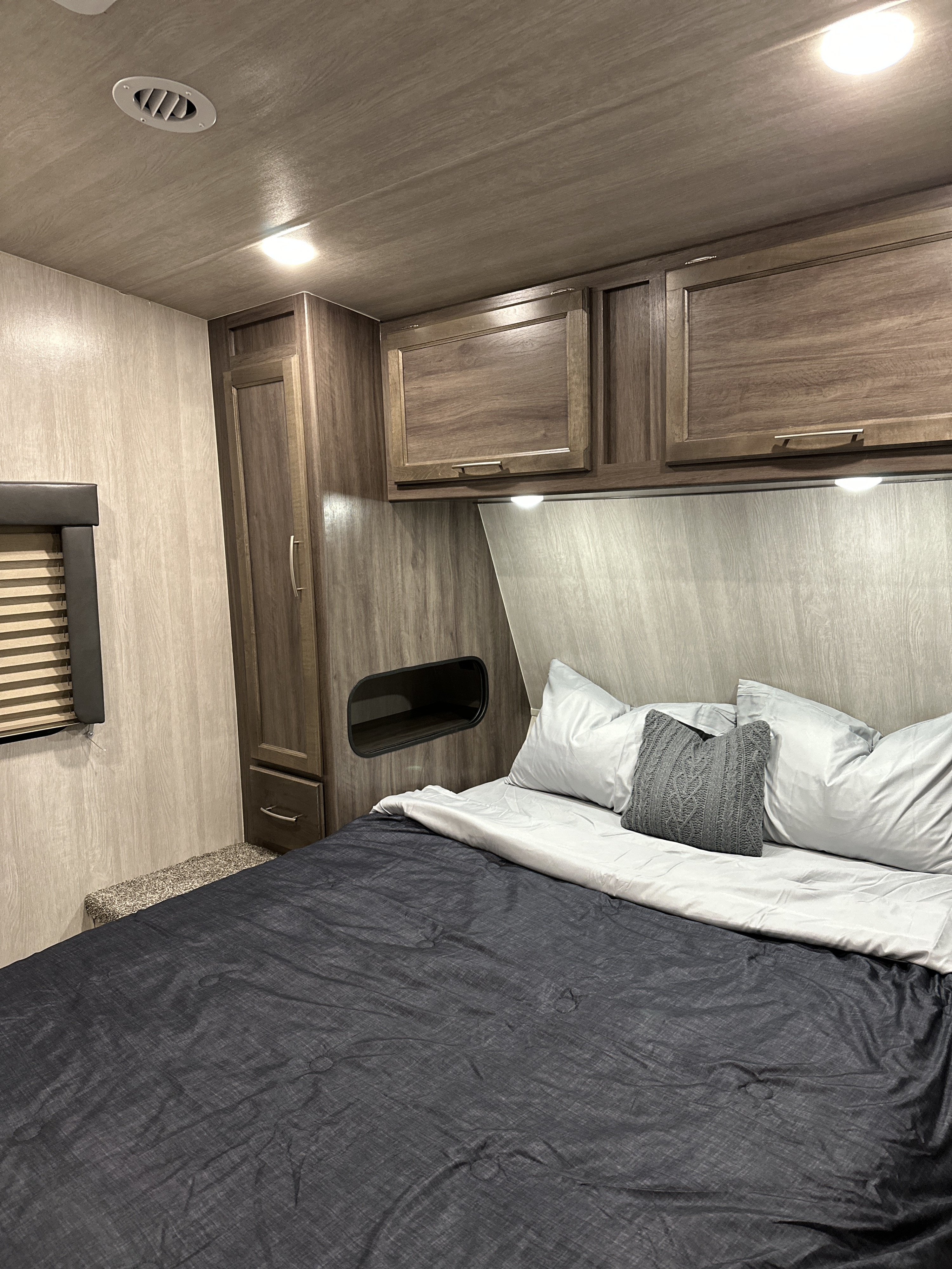 Cozy RV rental bedroom with bed, built-in cabinets, and a window for comfortable travels.. Genesis Supreme Rv Genesis Supreme 2023