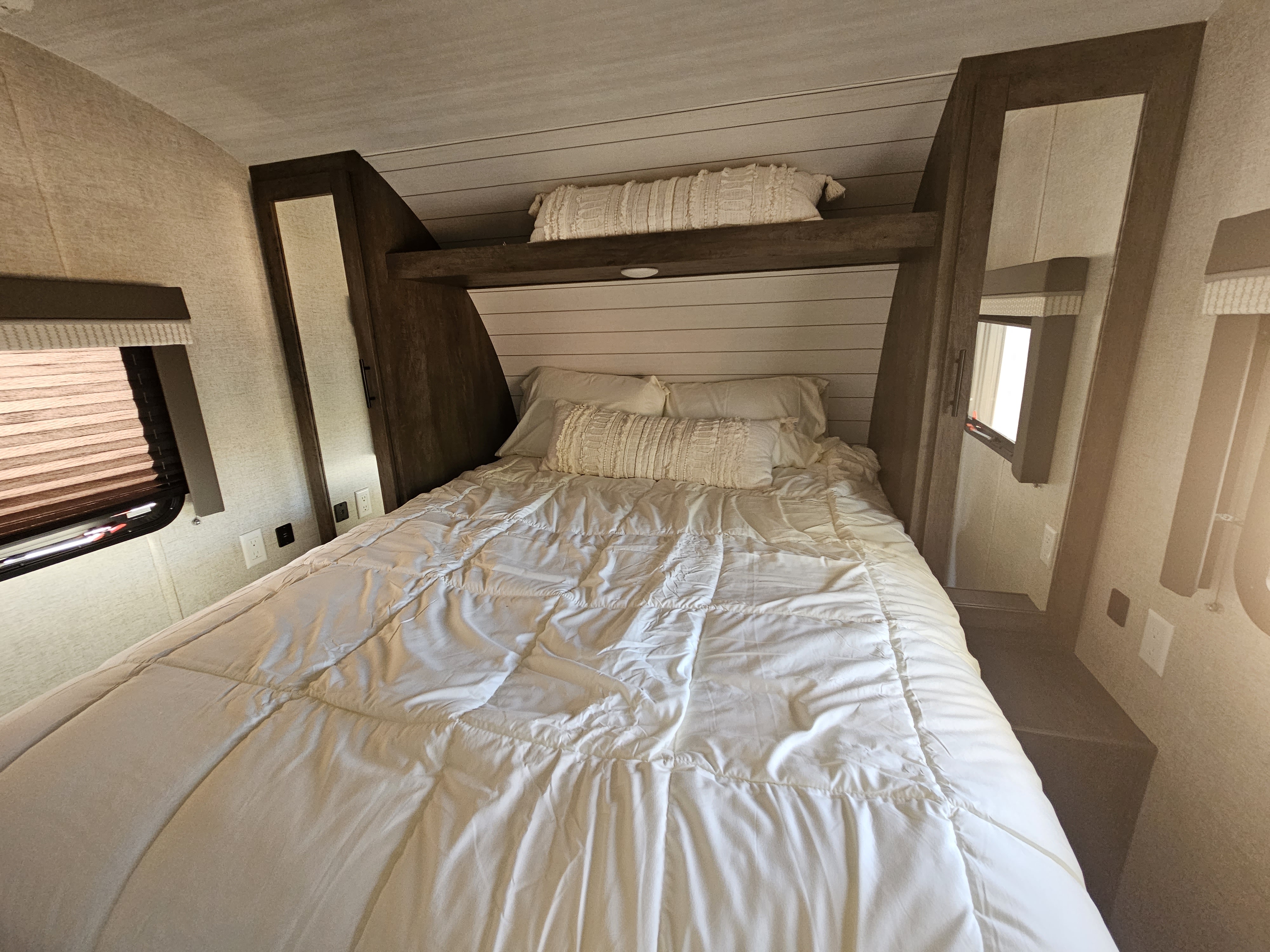 master bedroom with sheets and comforter, and pillows. Forest River Wildwood X-Lite 2021