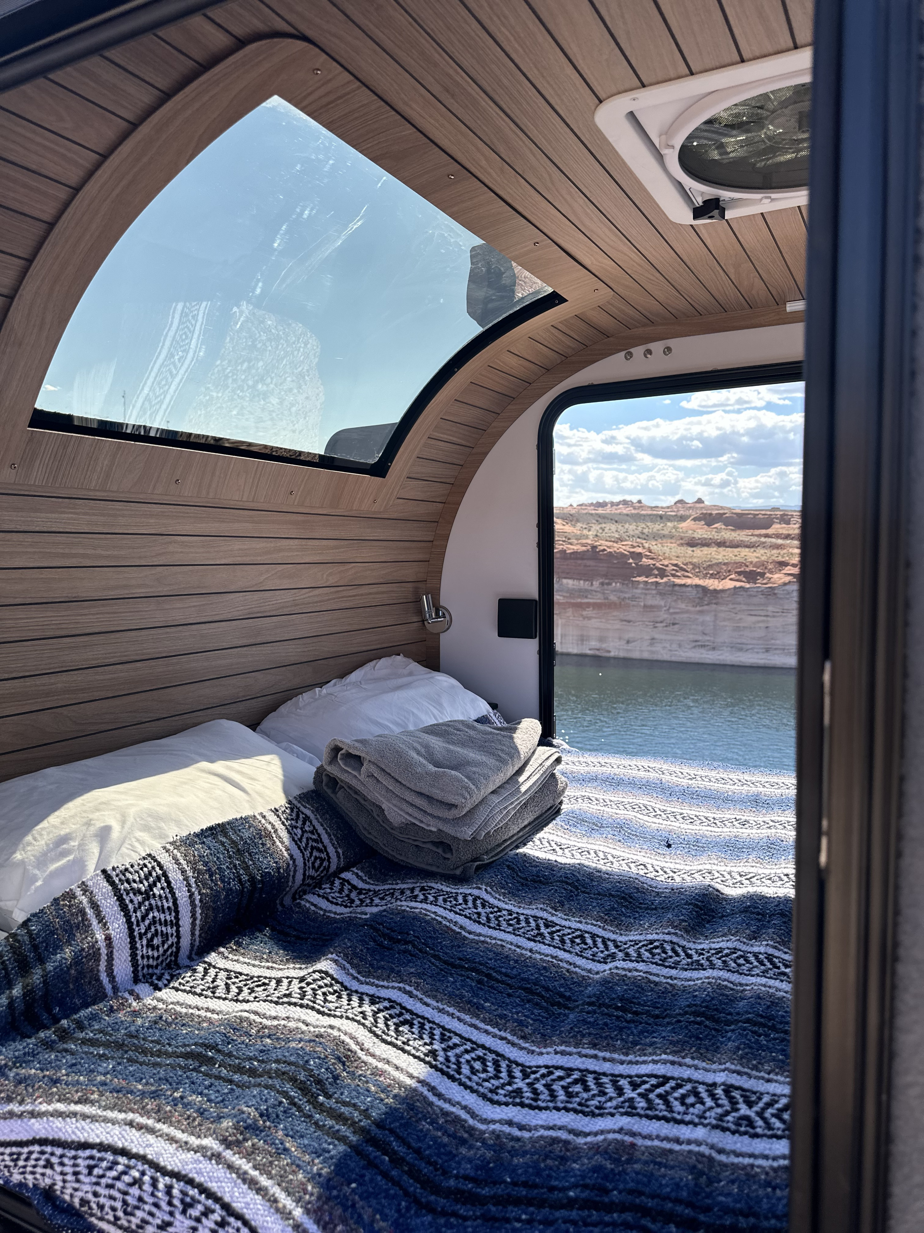 RV rental bed inside, with stunning lake and red rock views outside.. Cedar Ridge Vega 2.0 Teardrop 2024