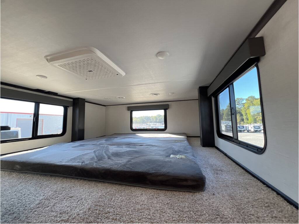 Spacious RV rental bunk area with comfy mattress, multiple windows, and overhead AC.. Keystone Alpine 2025