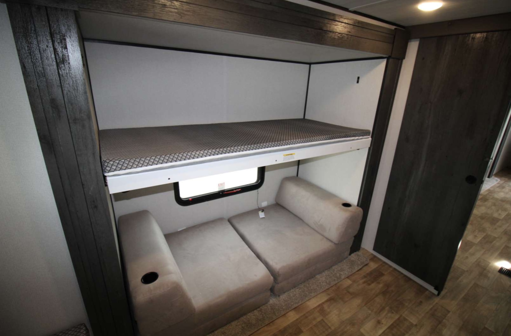 RV rental bunk bed with a comfy mattress, above versatile modular seating & an emergency exit window.. Keystone RV Hideout 2022