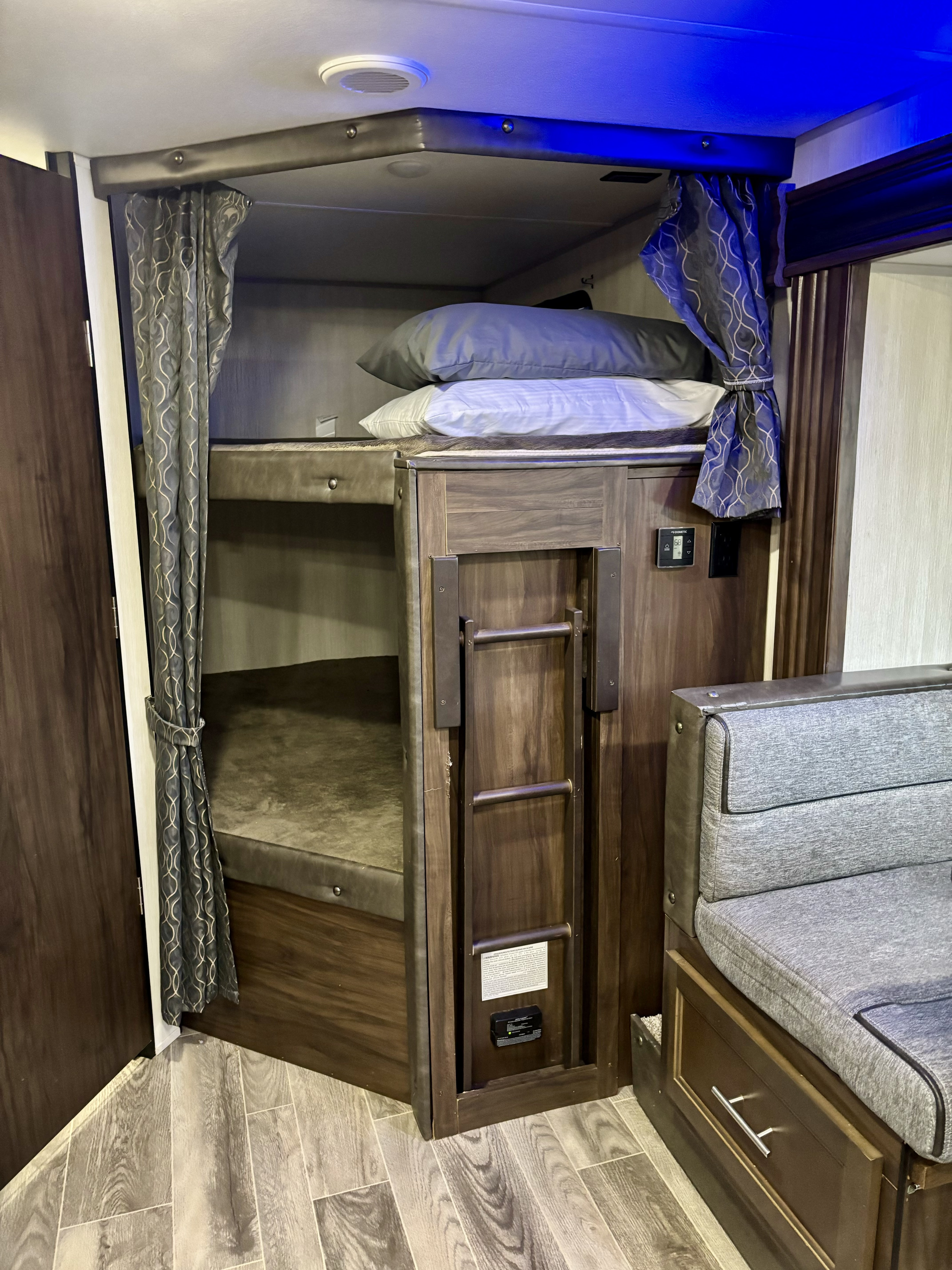 Cozy RV rental interior with bunk beds, ladder, and dinette seating, offering comfortable family space for travel.. Forest River Cherokee Grey Wolf 2019