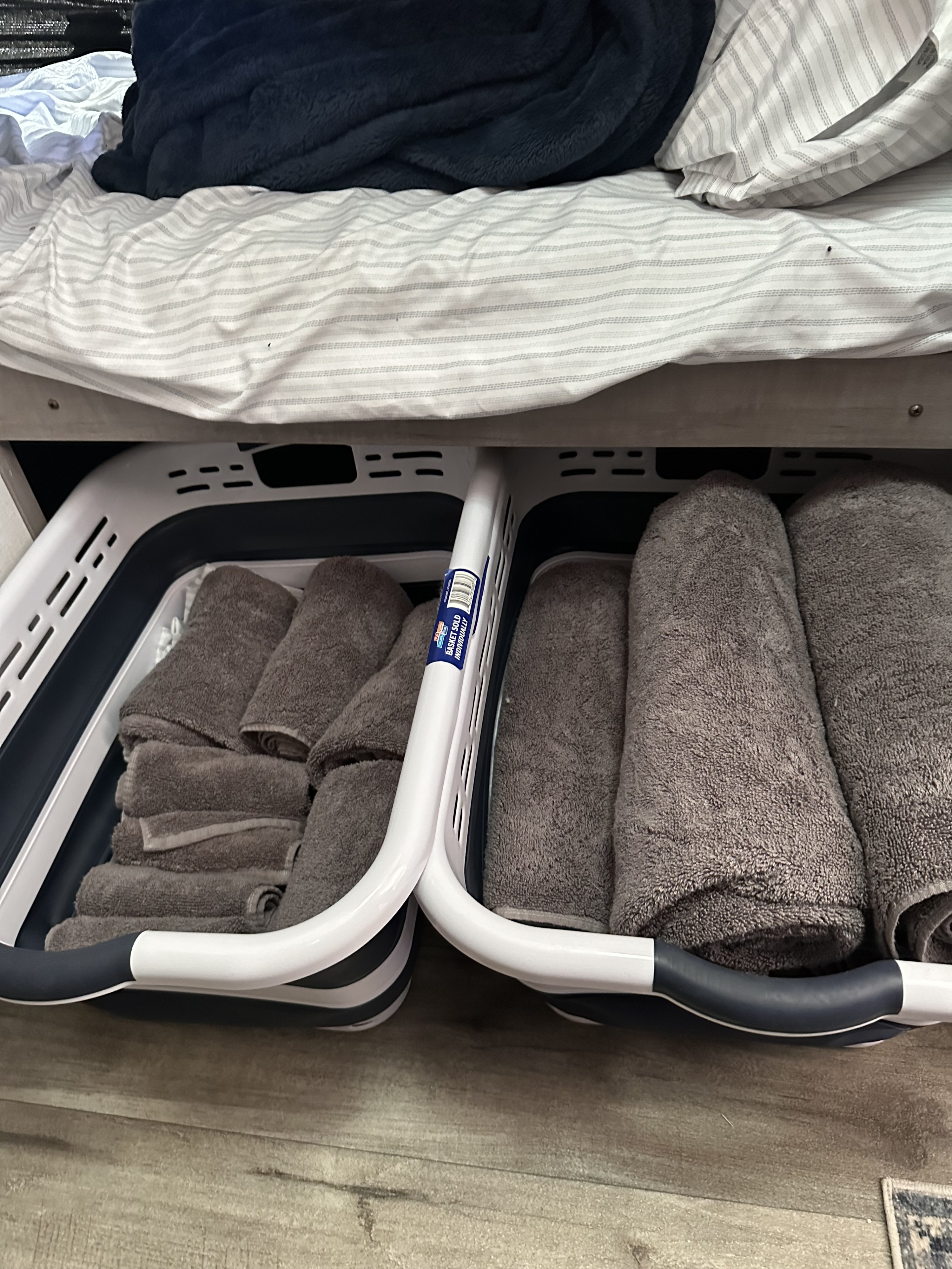 Efficient RV rental storage: Gray towels neatly organized in under-bed collapsible baskets, maximizing space.. Coleman Lantern 17b 2024