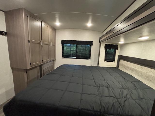 RV rental: Inside a well-appointed bedroom with a large bed, integrated wooden cabinets, and windows with blinds.. Crossroads Sunset Trail Super Lite 2022