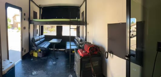 Inside this versatile RV rental, a toy hauler layout with bunk beds, dinette, and gear storage visible.. Forest River Cherokee Wolf Pack Toy Hauler 2021