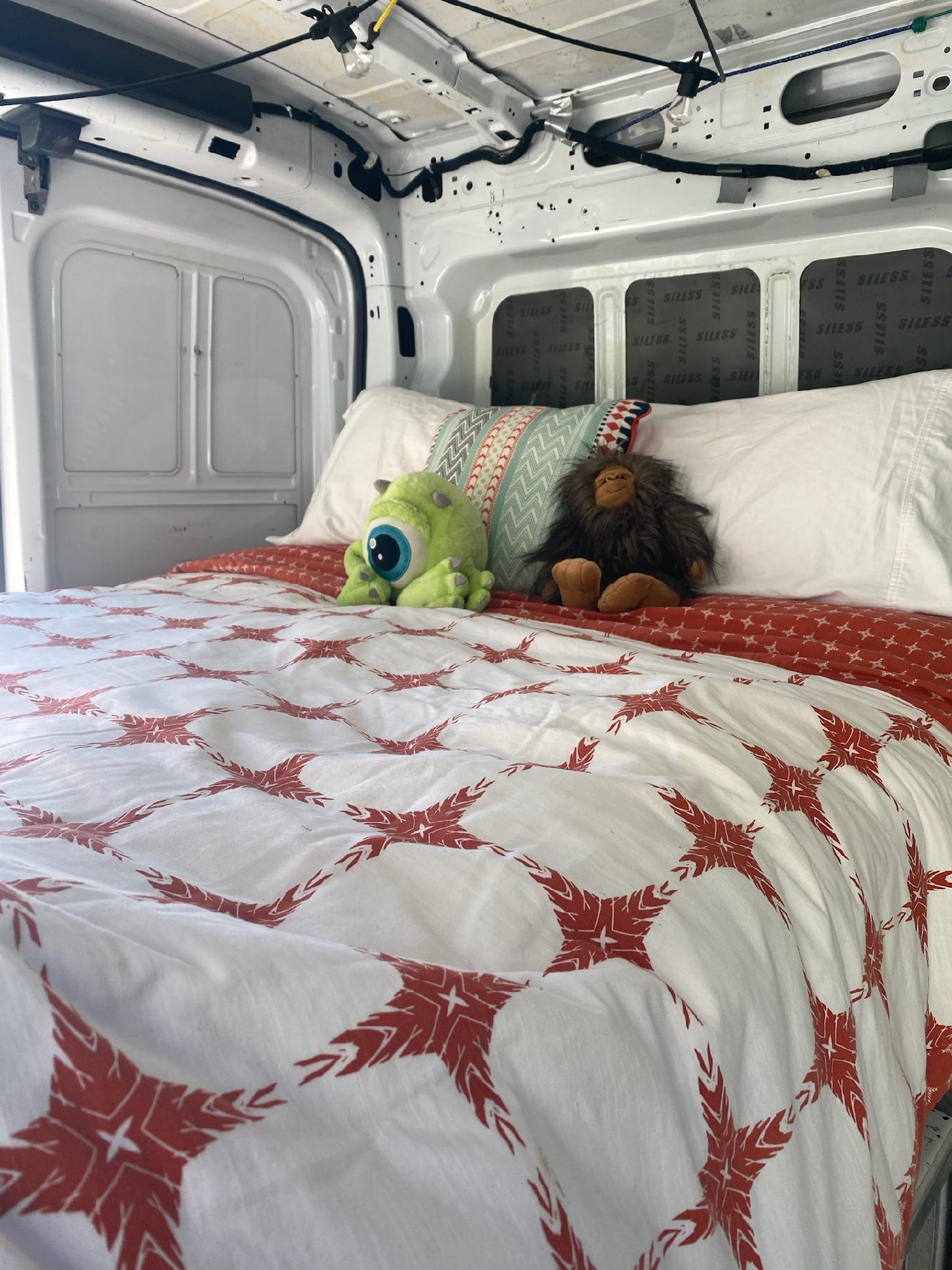Comfortable camper van bed in an RV rental, featuring playful plush toys & sound-dampened walls.. FORD Ford Transit 2015