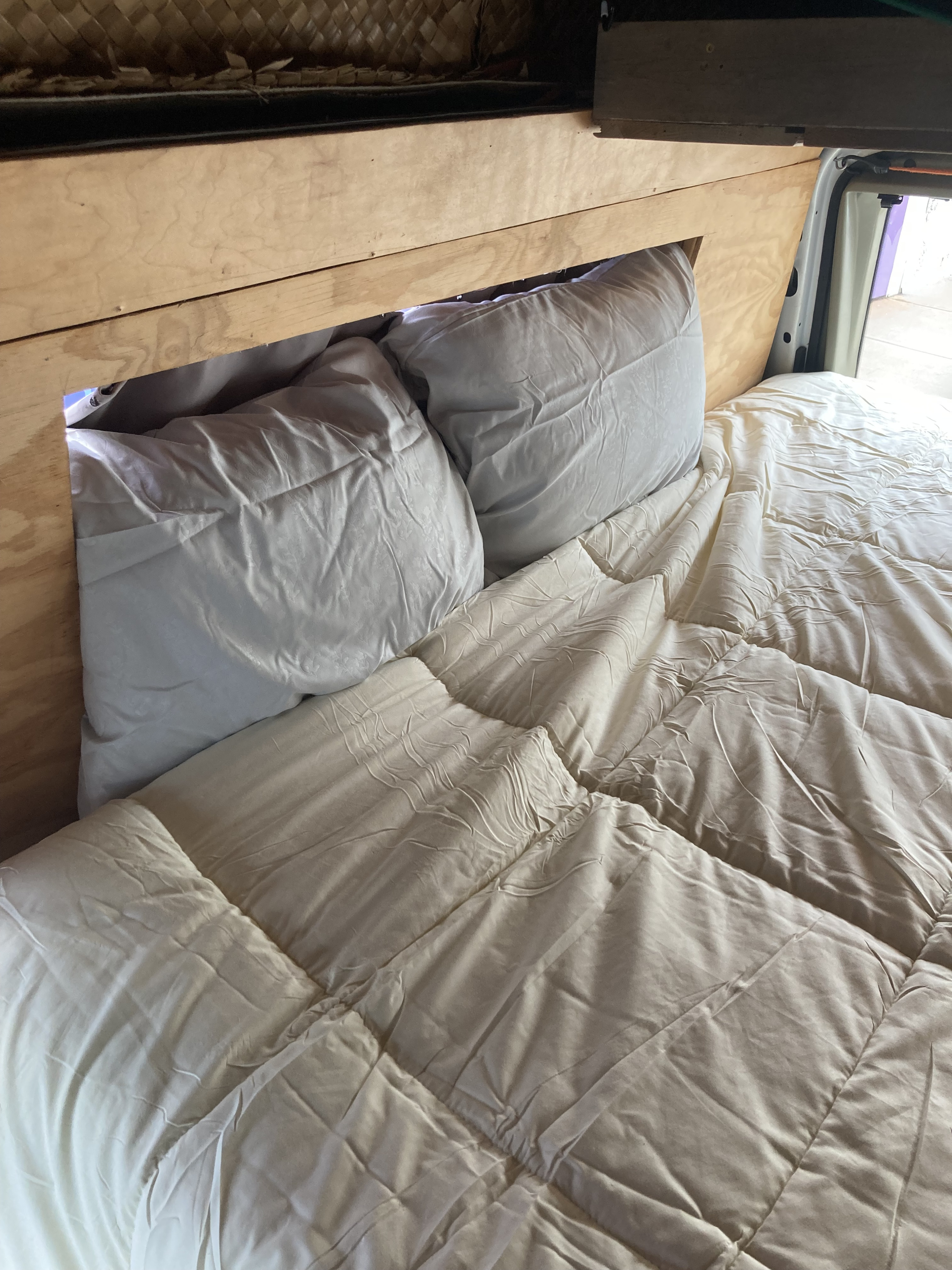 Comfortable RV rental bed features soft pillows & a quilted comforter within a wooden frame.. FORD E-150 2004