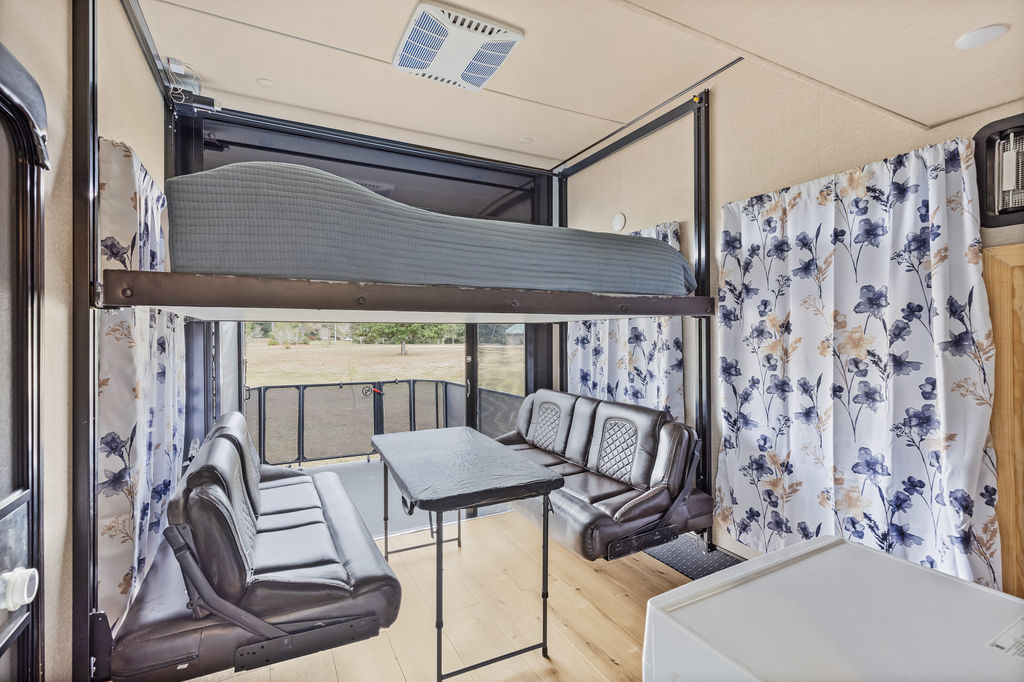 RV rental interior: versatile space with a drop-down bunk bed, sofas, table, and large rear opening to nature.. Grand Design Momentum Toy Hauler 2018
