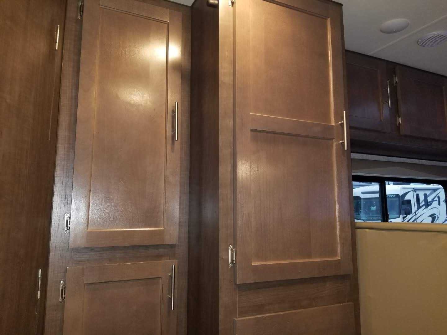 RV rental interior: Tall, warm wood storage cabinets with sleek silver bar handles and additional overhead cupboards.. Adventurer Adventurer Motorhome 2019