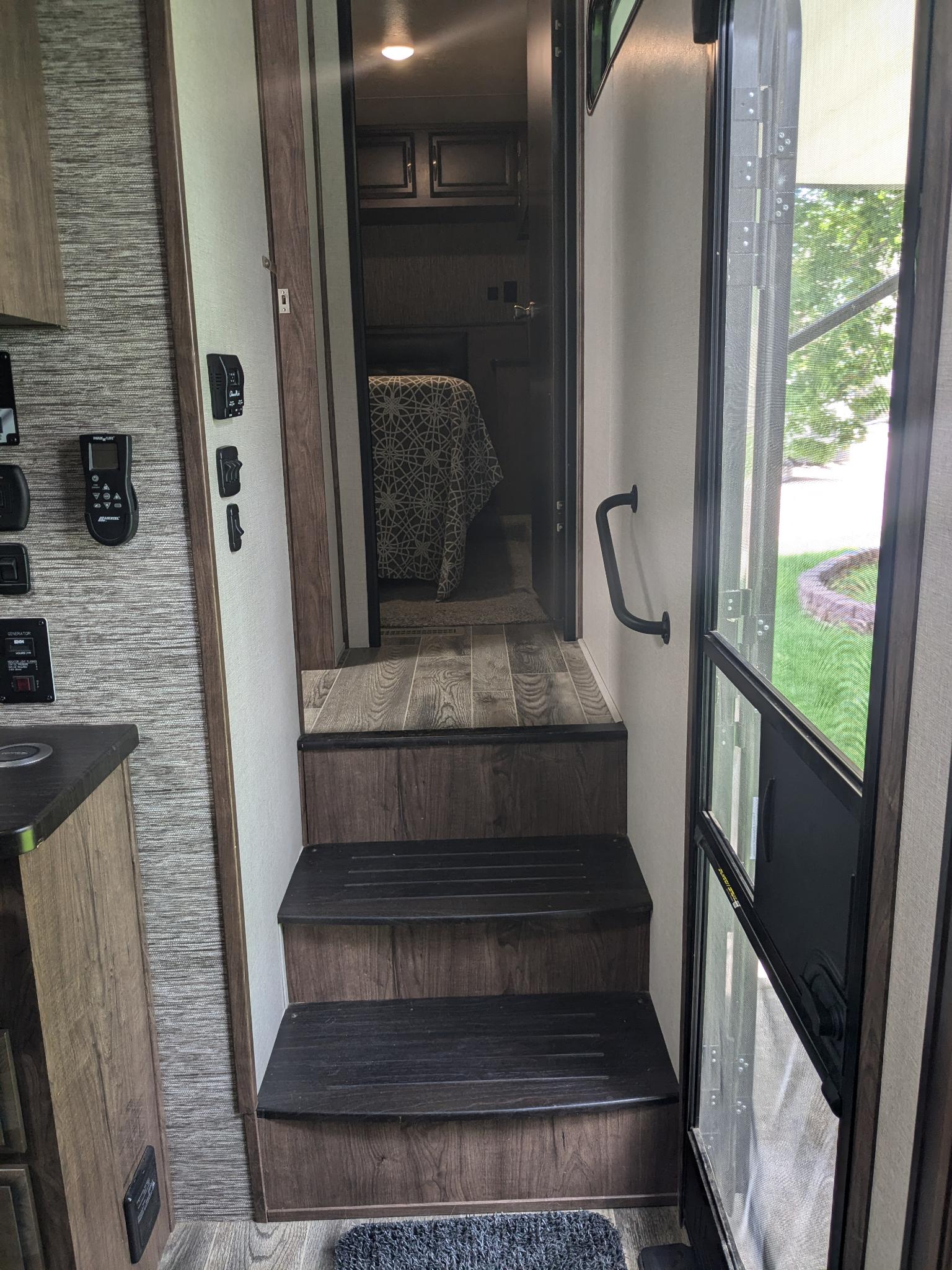 RV rental interior: Steps lead to the bedroom. Controls are on the left wall, entry door and screen on the right.. K-Z Manufacturing Venom V3411TK 2020