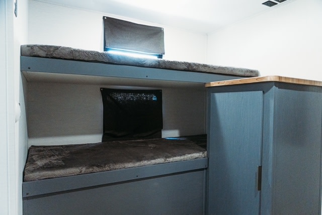 This RV rental offers cozy bunk beds, with soft bedding, window shades, and built-in lighting.. Forest River Tracer 2024