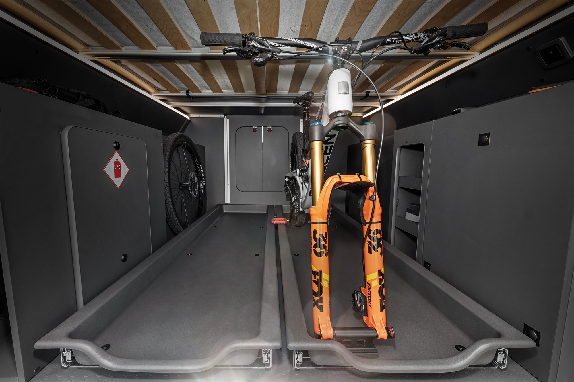 RV rental: Two mountain bikes secured on pull-out trays in a well-lit cargo area, typically under a bed.. Auto Trail Expedition 68 2025