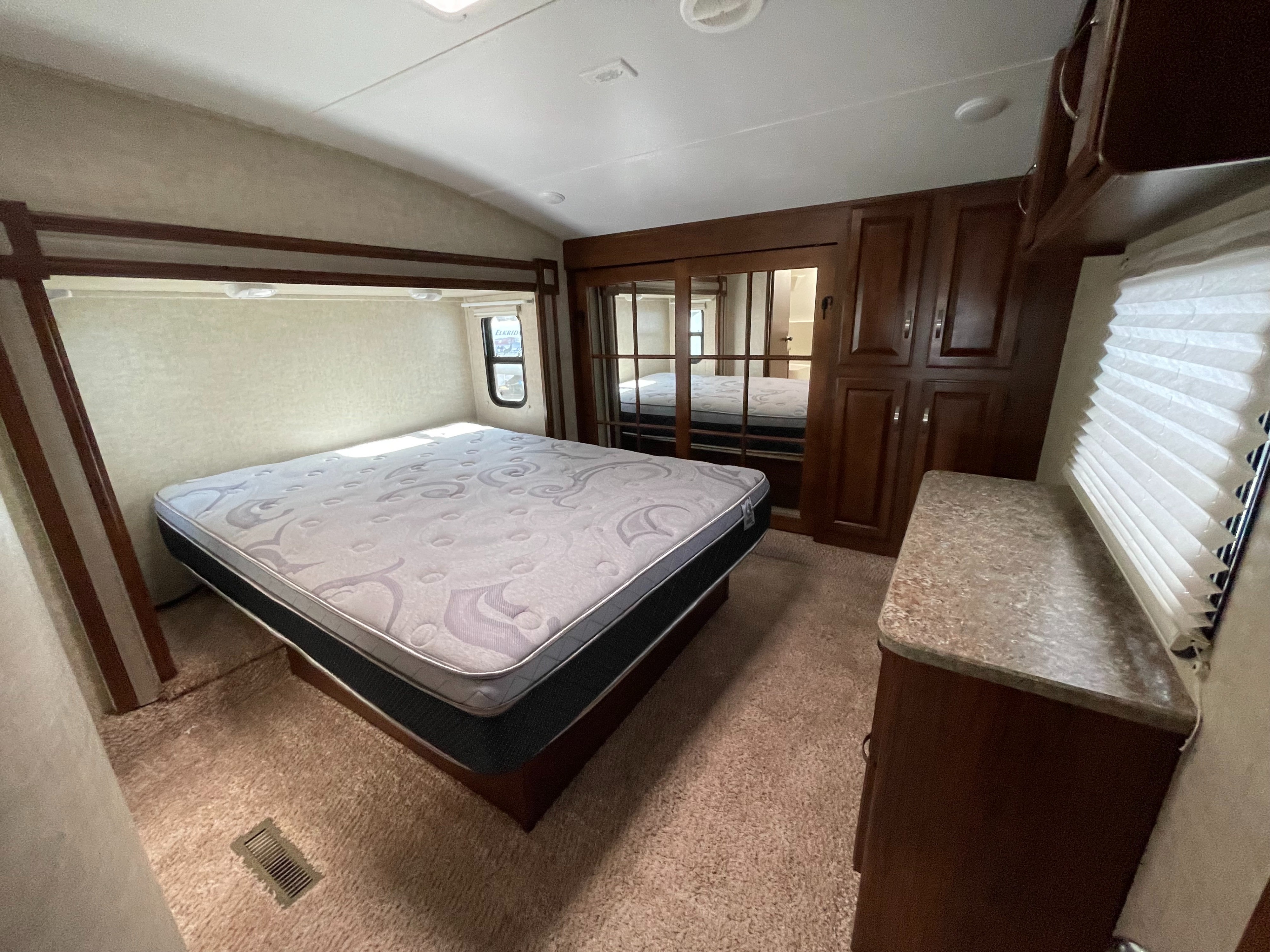 This inviting RV bedroom, ready for rv rental, offers a plush bed, ample storage, and a bright, clean interior.. Keystone Laredo 2013