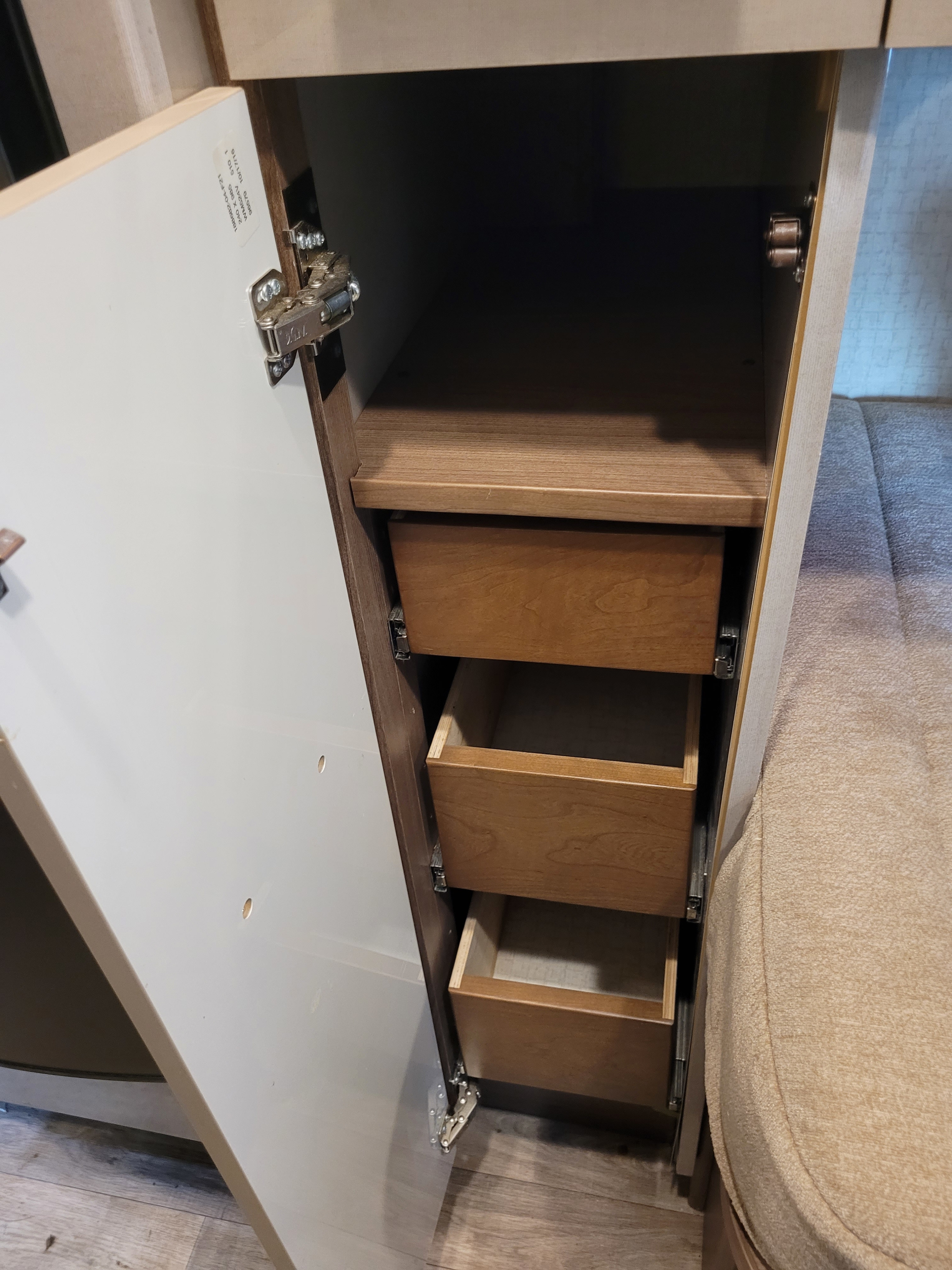 RV rental interior: Open cabinet showing a top shelf and three wooden pull-out drawers, offering efficient storage.. Winnebago View 2017
